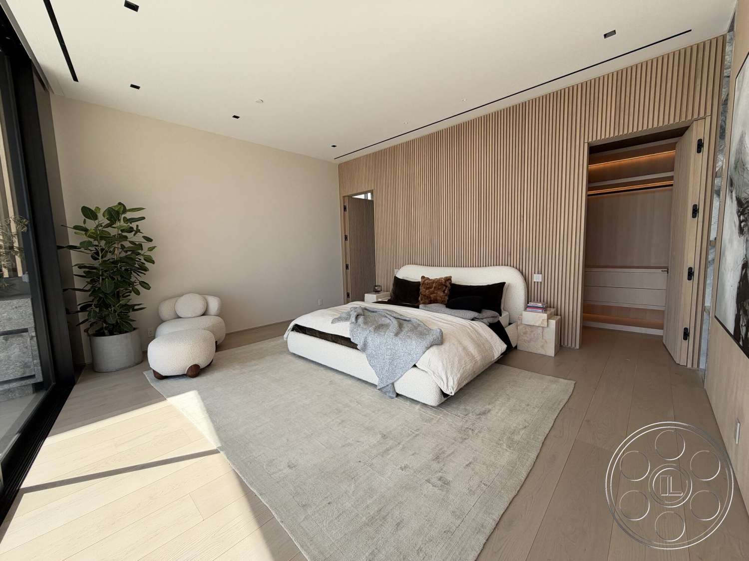 Modern 532 - minimalist decor, neutral color palette, light wood flooring, floor-to-ceiling windows, plush area rug, open closet space, modern bed with upholstered headboard, natural light-filled bedroom, indoor plant in ceramic pot, vertical slat wood wall treatment, soft fabric throws and pillows, contemporary closet door