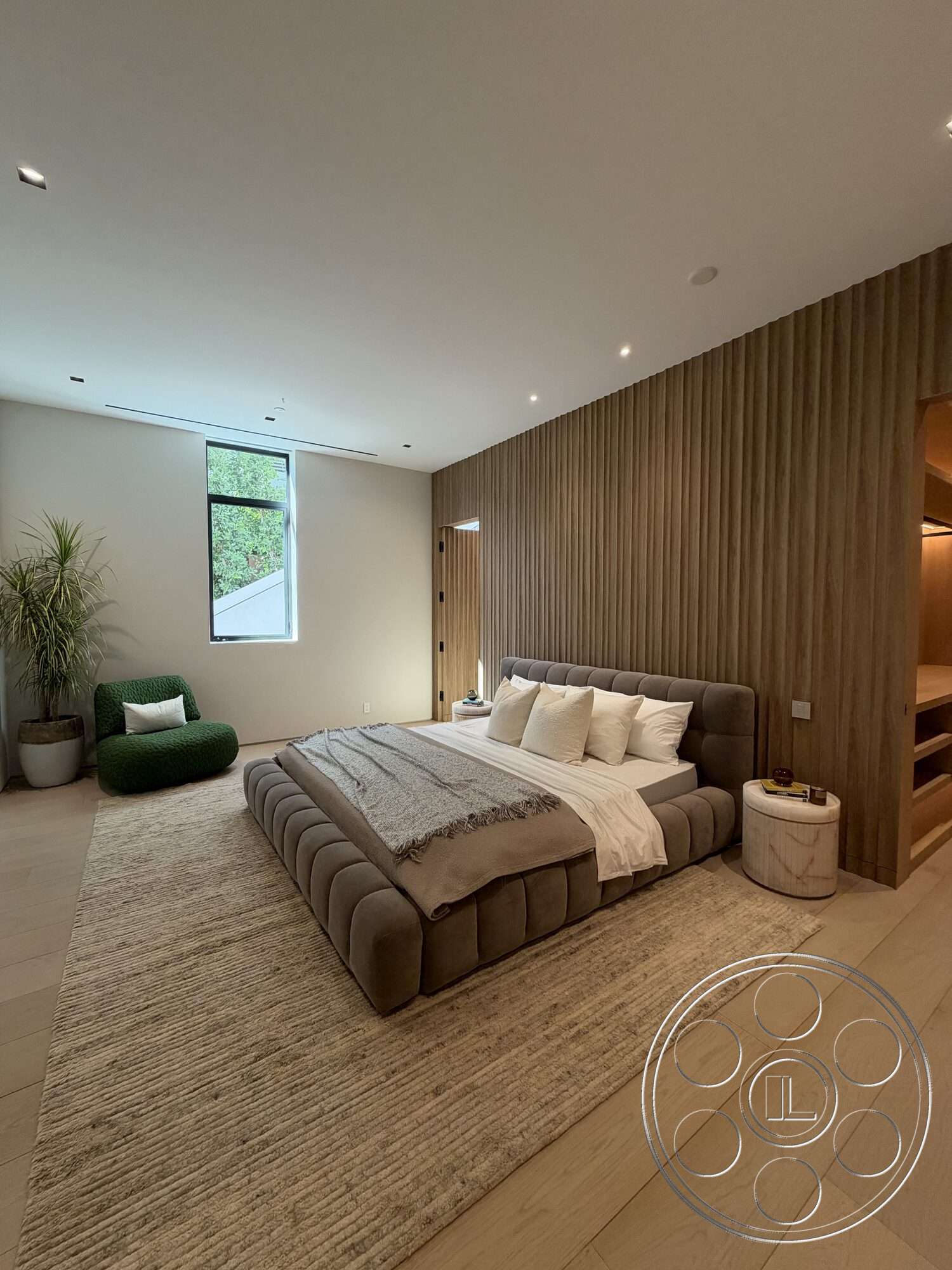 Modern 532 - neutral color palette, natural light, minimalist design, plant decor, cozy seating area, recessed ceiling lights, hardwood bedroom floors, open closet space, textured wooden accent wall, window with black frame, upholstered platform bed, bedroom area rug
