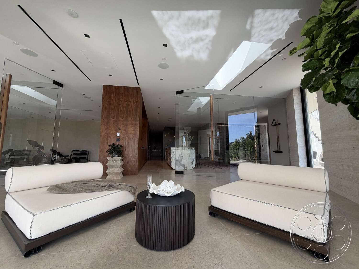 Modern 532 - neutral color palette, round coffee table, contemporary furniture, skylights, polished marble flooring, glass partition walls, recessed ceiling lighting, indoor potted plant, rich wood accent wall, low-profile lounge chairs