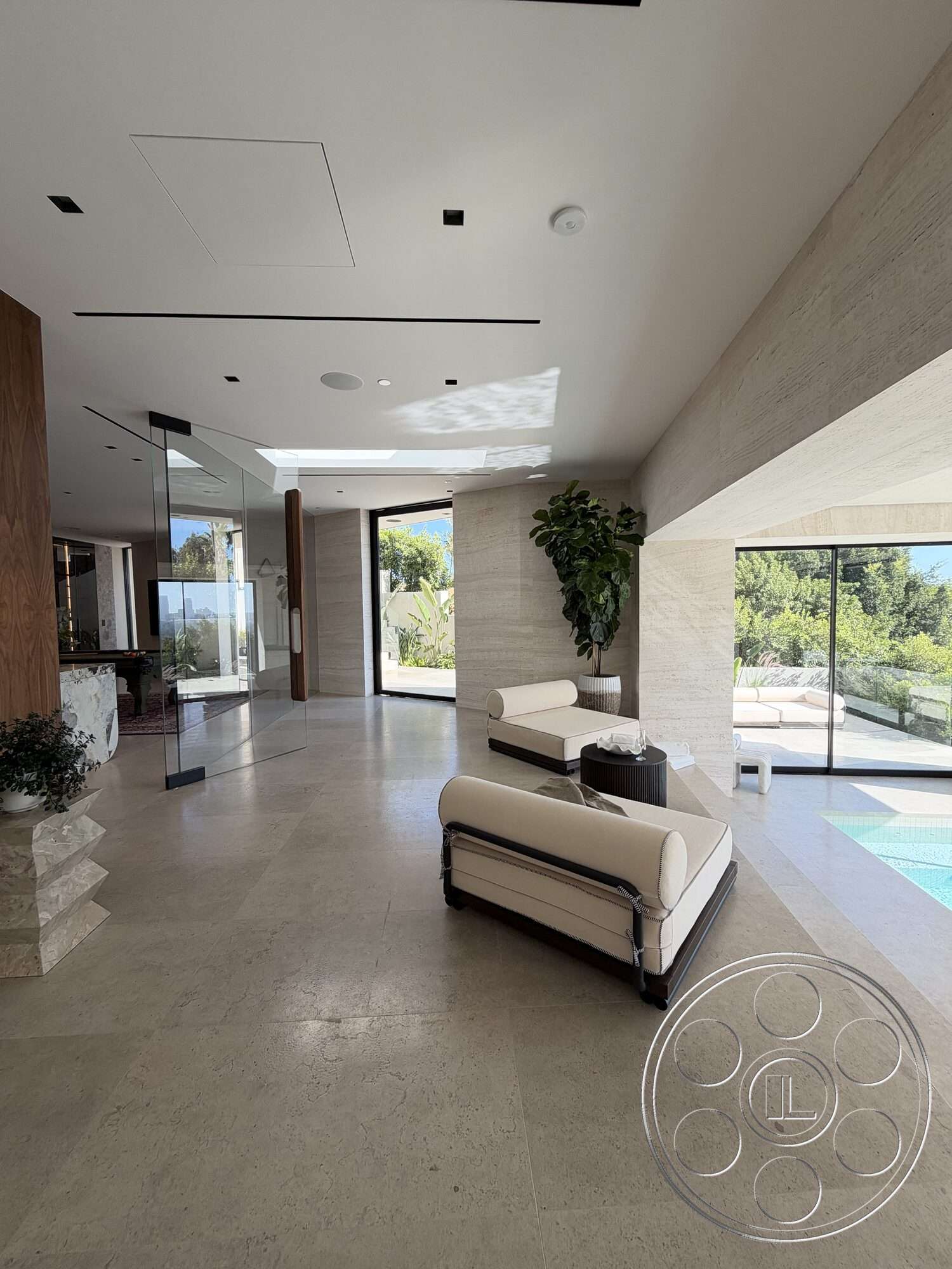 Modern 532 - neutral color palette, glass wall partitions, open floor plan layout, potted indoor plants, natural light emphasis, modern furniture design, exposed wood accent wall, large windows with outdoor view, travertine floor tiles, minimalist decor details
