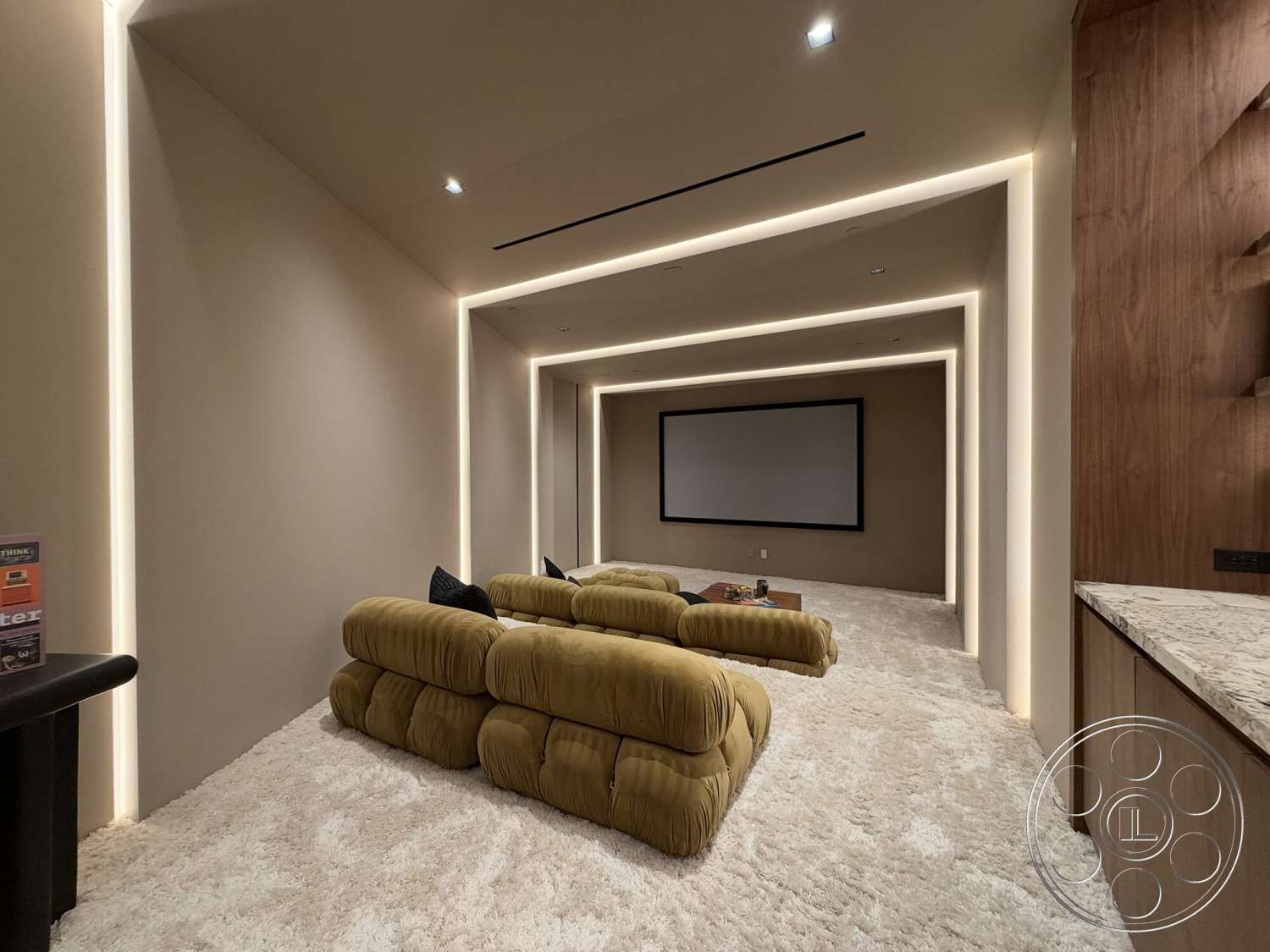 Modern 532 - wood cabinetry, stone countertop, textured wall treatment, modern minimalist design, curved seating arrangement, plush carpet flooring, recessed lighting details, wall-mounted projection screen, cozy theater room, soft yellow upholstered sofas