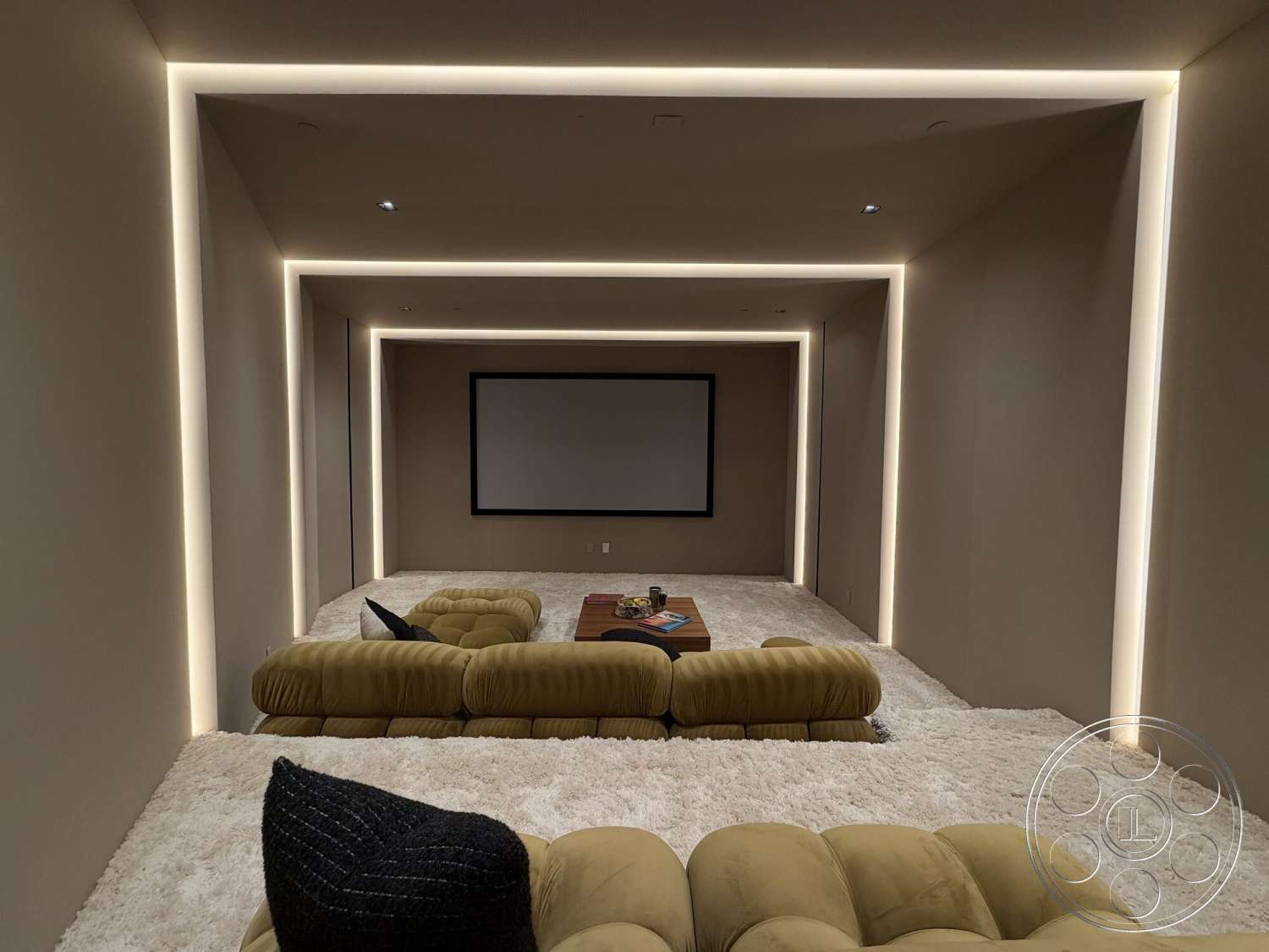 Modern 532 - minimalist design elements, neutral wall color, soft carpet flooring, interior home theater, LED strip lighting, modular seating arrangement, low-profile coffee table, projection screen area, cozy lounge atmosphere