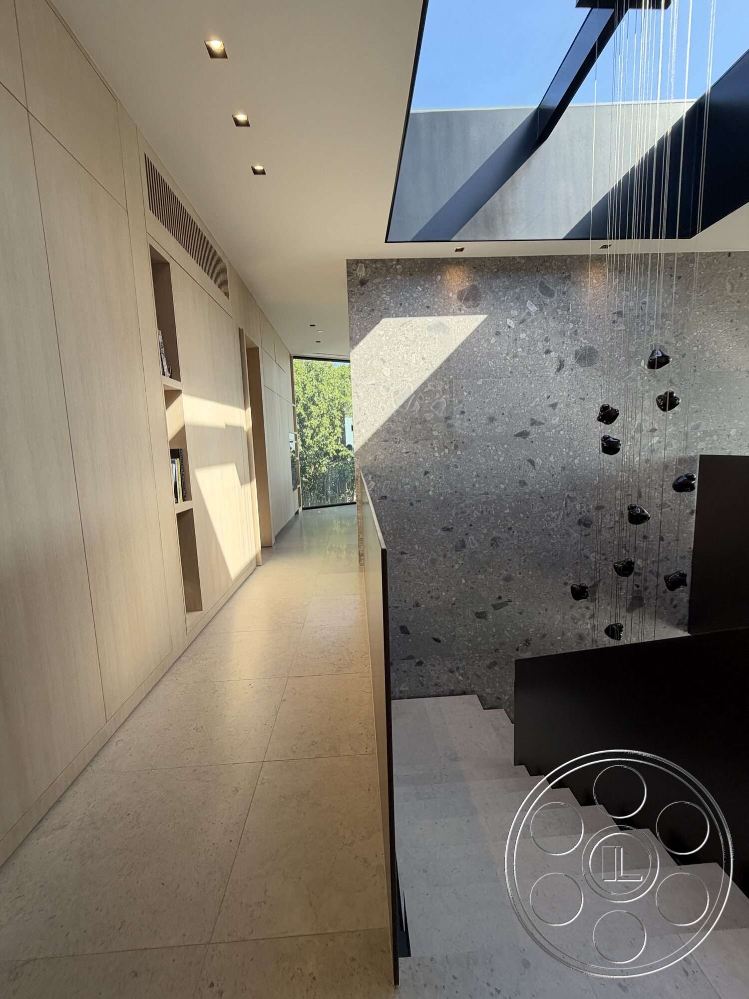 Modern 532 - natural light, minimalist design, stone accent wall, modern architectural style, polished stone flooring, glass skylight, recessed lighting fixtures, built-in shelving units, open hallway layout, light-colored wood wall paneling, floating black staircase