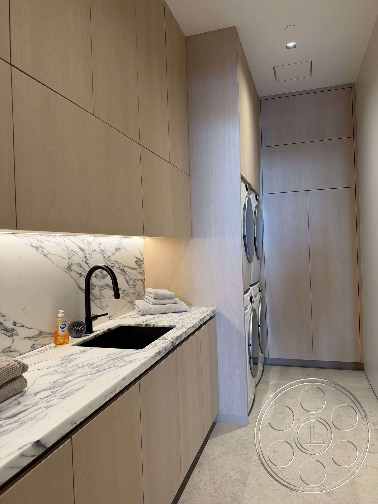 Modern 532 - recessed lighting, minimalist design, light wood cabinetry, marble countertop, polished stone flooring, textured backsplash, black undermount sink, stacked washer and dryer