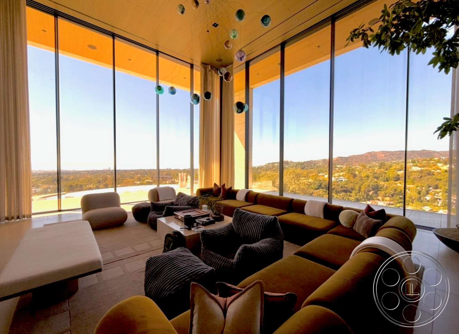 CK Mansion - indoor plants, open floor plan, modern coffee table, floor-to-ceiling windows, natural stone flooring, wood ceiling panels, decorative throw pillows, rounded sofa seating, curtains with sheer fabric