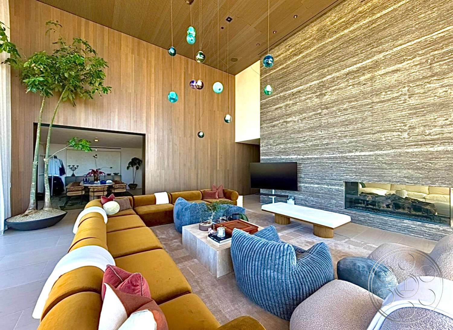 CK Mansion - minimalist decor, open concept design, glass fireplace, rectangular coffee table, stone feature wall, textured wood paneling, modern sectional sofa, plant accent, concrete floor tiles, hanging decorative light fixtures, cozy living room layout