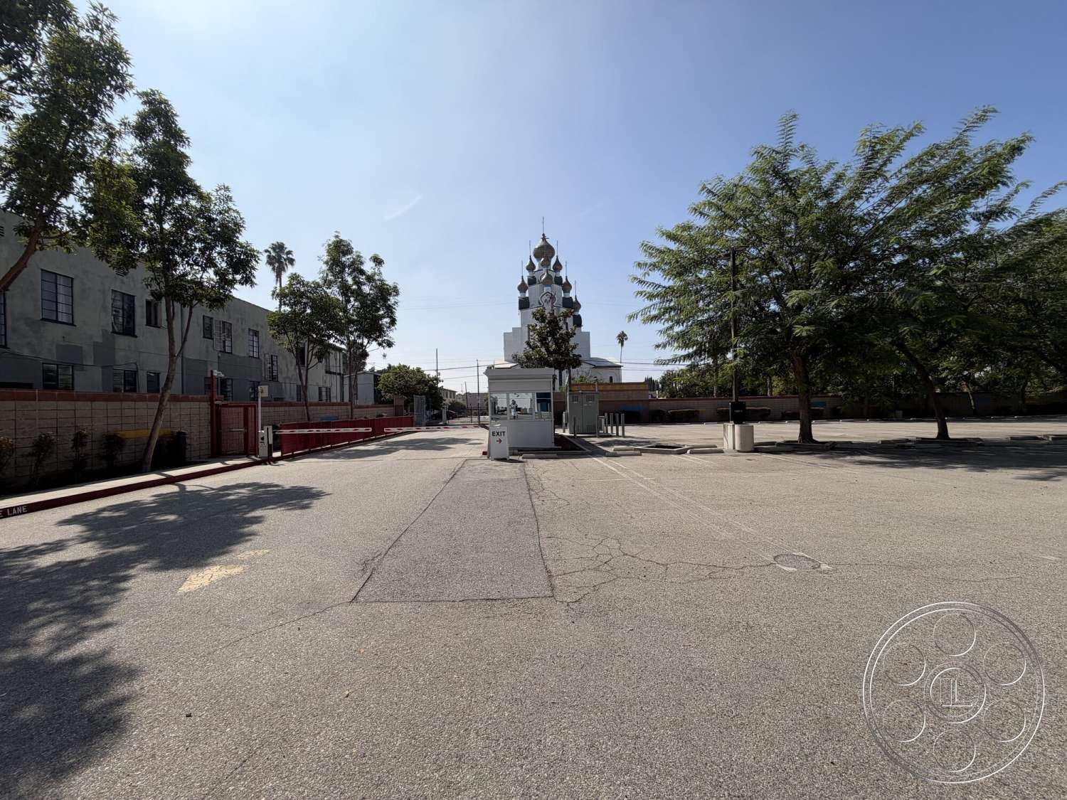 Office 130 - exterior, palm trees, asphalt parking lot, commercial property setting, red brick border, tree-lined entrance, stucco building walls, decorative dome structure, sidewalk driveway