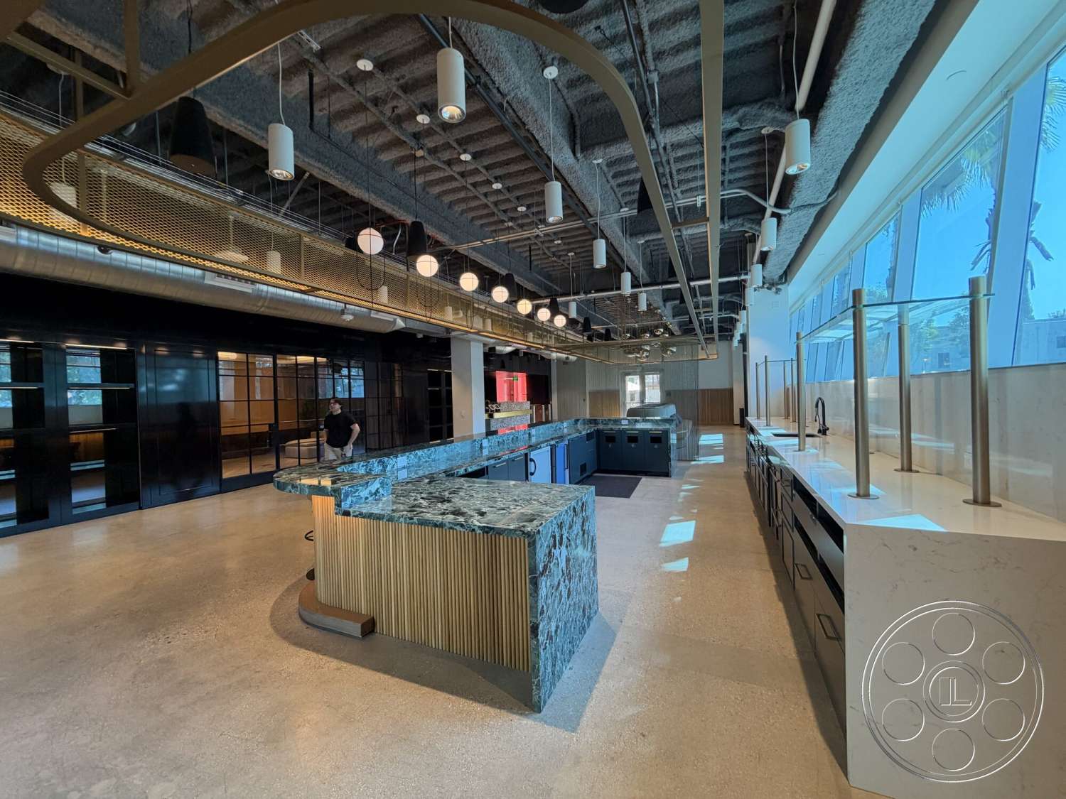 Office 130 - concrete flooring, open concept layout, floor-to-ceiling windows, textured wall treatment, pendant lighting fixtures, granite kitchen countertops, exposed ductwork ceiling, wood panel kitchen cabinetry, steel kitchen appliances, black glass cabinet doors