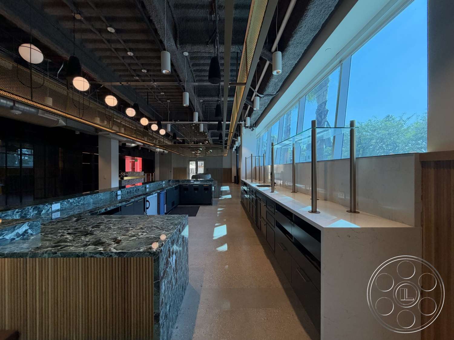 Office 130 - metal railings, black cabinetry, textured ceiling finishes, open layout kitchen, floor-to-ceiling glass windows, exposed concrete flooring, industrial style lighting, linear lighting fixtures, wood panel wall treatment, marble countertop with green veining