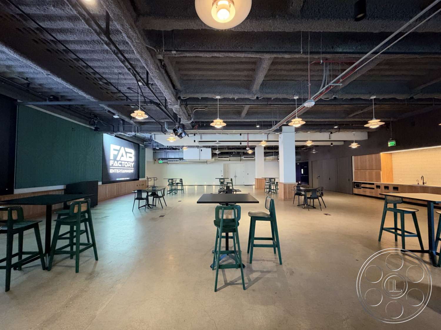Office 130 - floor-to-ceiling windows, metal bar stools, wood accent walls, black painted walls, glass partition walls, industrial-style light fixtures, exposed concrete flooring, open commercial layout, painted ceiling panels, modern bar height tables, kitchenette area with wood cabinetry