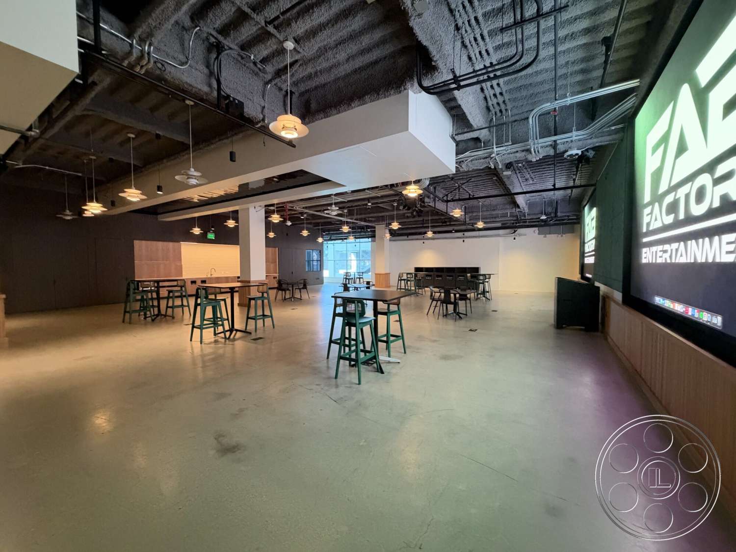 Office 130 - open floor plan, multifunctional space, suspended lighting fixtures, floor-to-ceiling windows, metal bar stools, exposed concrete floor, wood panel accent wall, industrial ceiling, urban entertainment venue