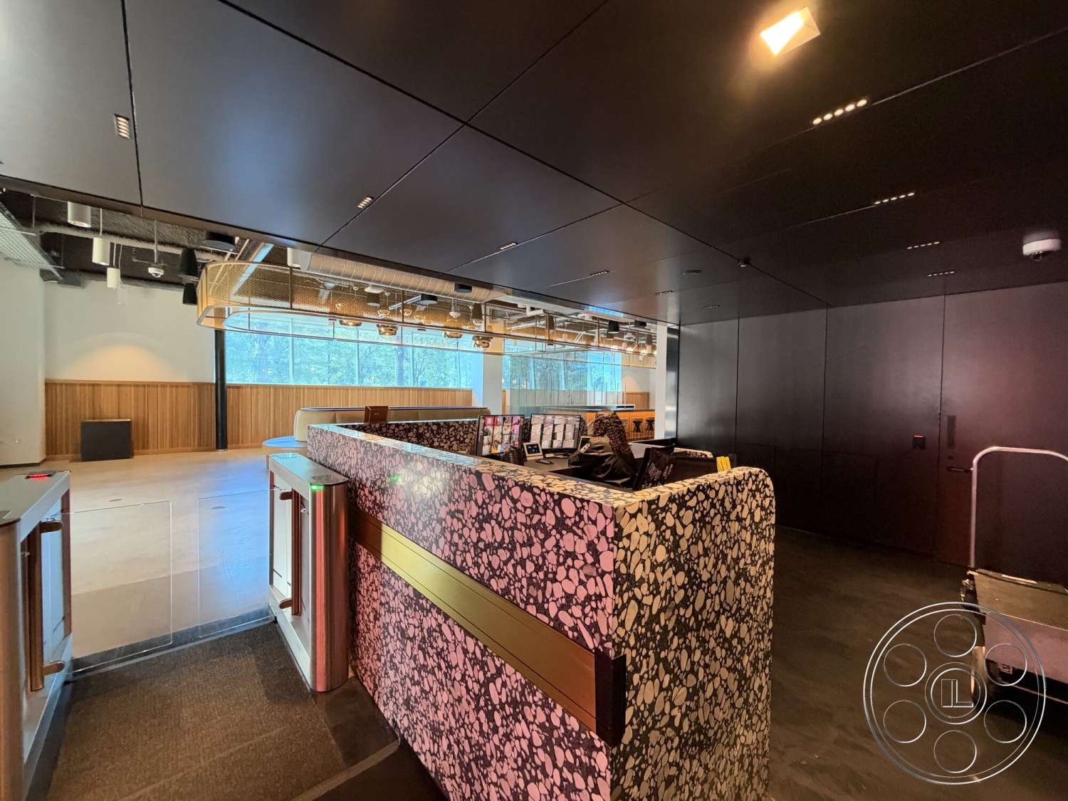 Office 130 - minimalist aesthetic, concrete flooring, modern architectural style, large floor-to-ceiling windows, wooden accent wall, dark wood paneling walls, exposed structural beams, terrazzo reception desk, metal ceiling elements, industrial design features, gold finished hardware