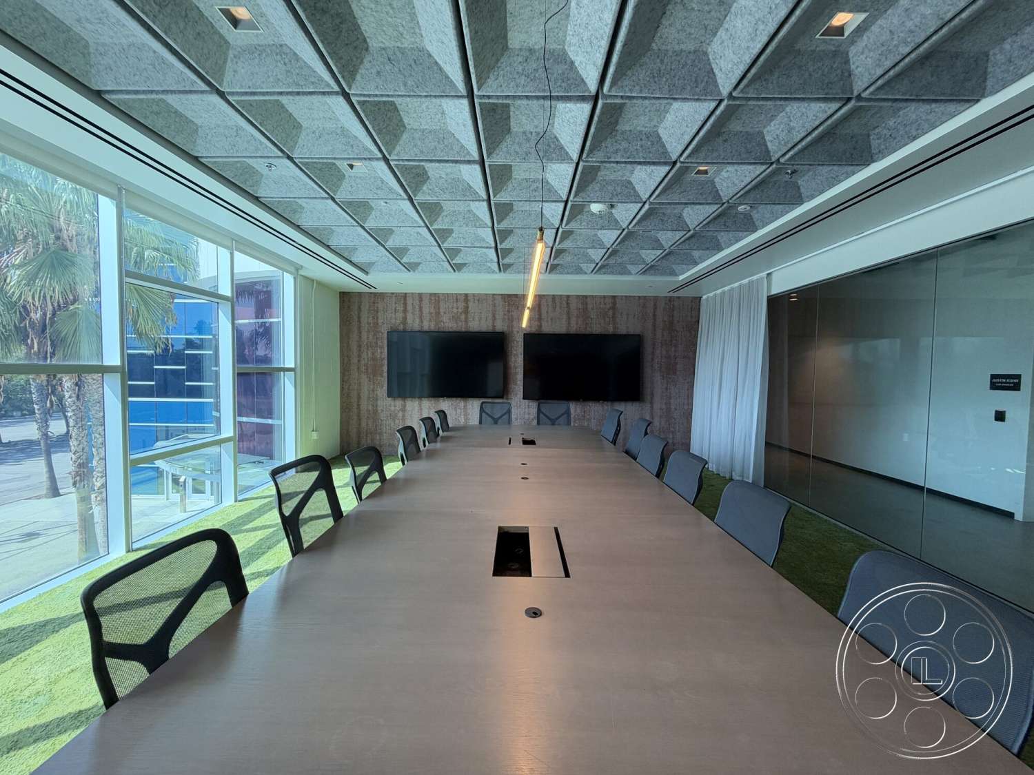 Office 130 - floor-to-ceiling windows, glass partition walls, LED pendant lighting, textured wood wall panels, green carpet flooring, hexagonal acoustic ceiling tiles, natural wood conference table, mesh-back office chairs, built-in display screens