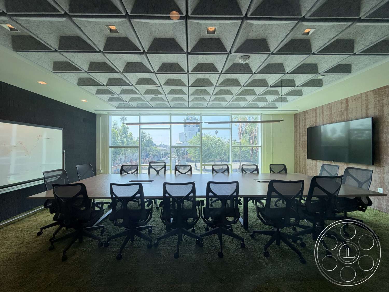 Office 130 - natural light, large conference table, floor-to-ceiling windows, urban view, functional meeting space, acoustic tile ceiling, modern office decor, green carpet flooring, executive office chairs, wood TV wall panel, glass whiteboard
