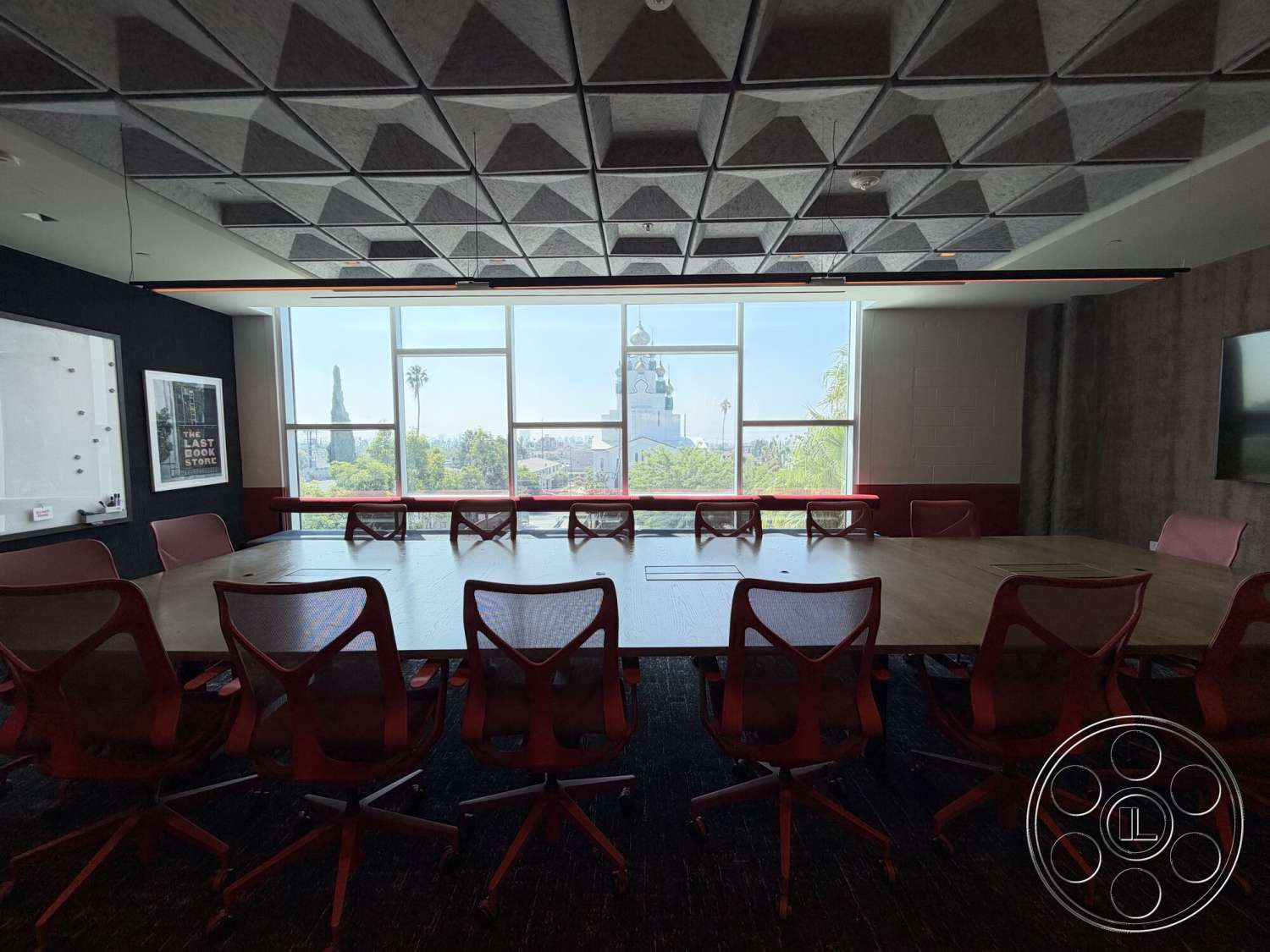 Office 130 - urban skyline view, large floor-to-ceiling windows, black accent wall, ergonomic office chairs, modern office design, rectangular conference table, acoustic tile ceiling, carpeted office flooring, polished wood table surface, dark red wall paneling, textured fabric wall finish