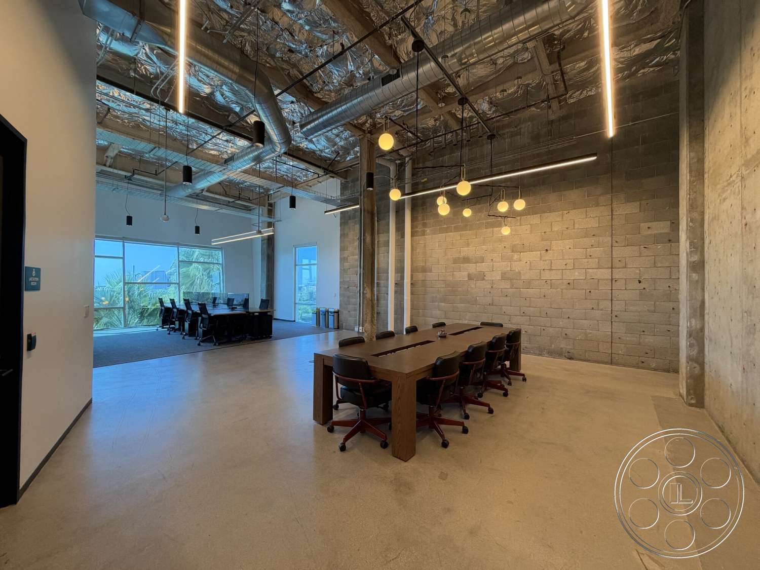 Office 130 - neutral color palette, polished concrete flooring, exposed concrete walls, floor-to-ceiling windows, industrial design elements, metal ductwork, exposed ceiling structure, modern office interior, conference room setting, rectangular conference table, commercial office environment, open layout workspace, black leather office chairs, large windows with views, pendant light fixtures