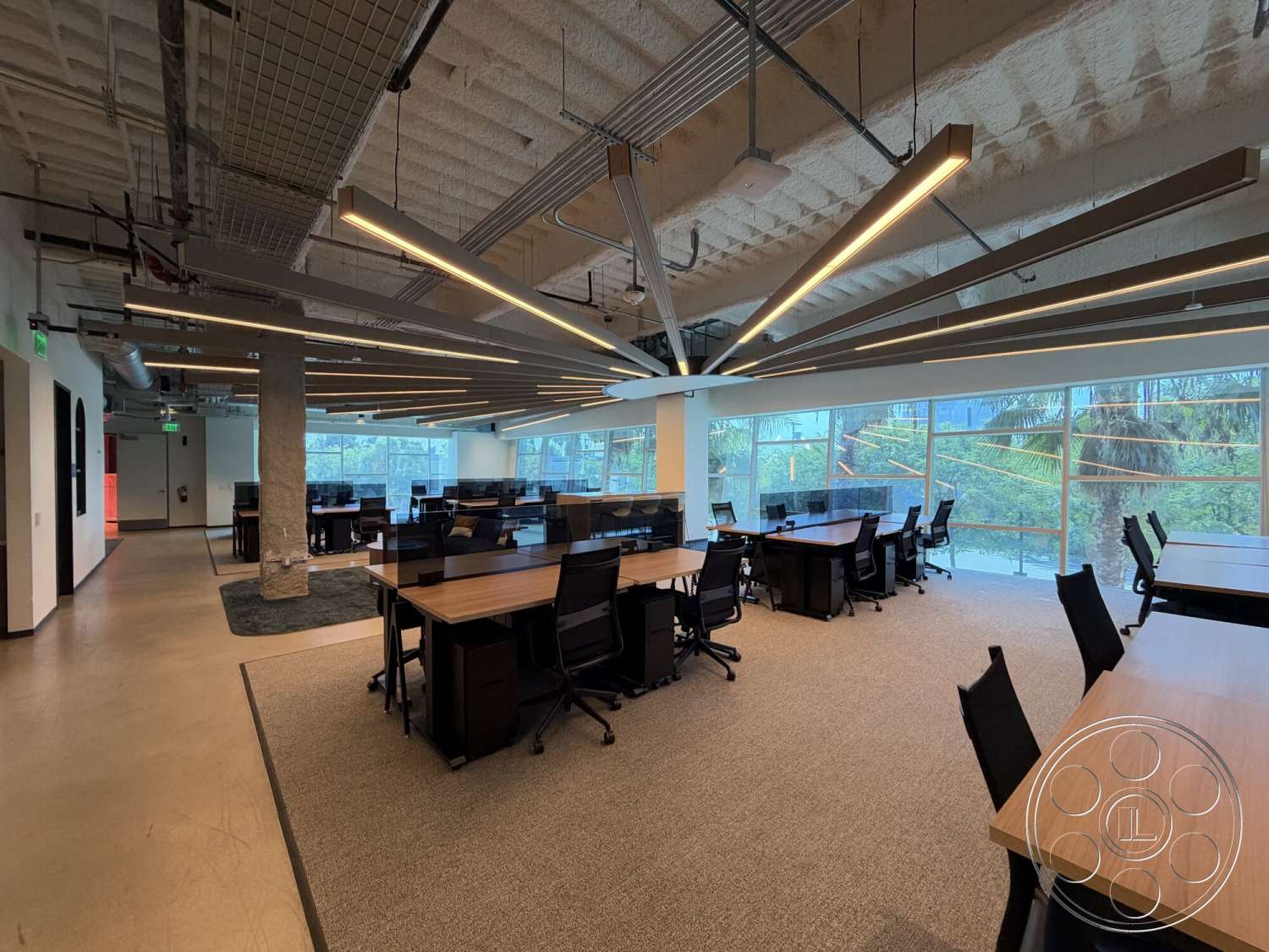 Office 130 - natural light, carpet flooring, large floor-to-ceiling windows, ergonomic office chairs, interior office space, modern workspace design, exposed concrete columns, wooden office desks, metal ceiling grids, suspended linear lighting
