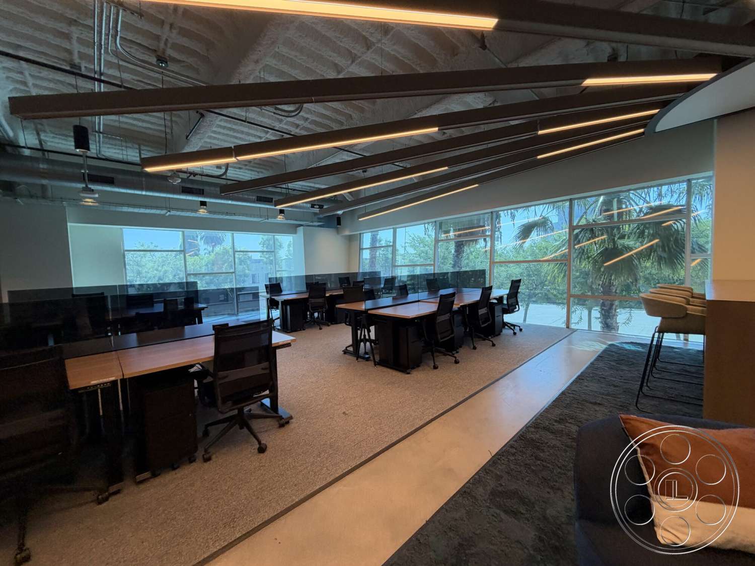 Office 130 - neutral color palette, exposed ceiling beams, glass partition walls, contemporary office design, carpet office flooring, open workspace layout, modern office chairs, industrial ceiling lights, large windows with view of palm trees, wood office desks