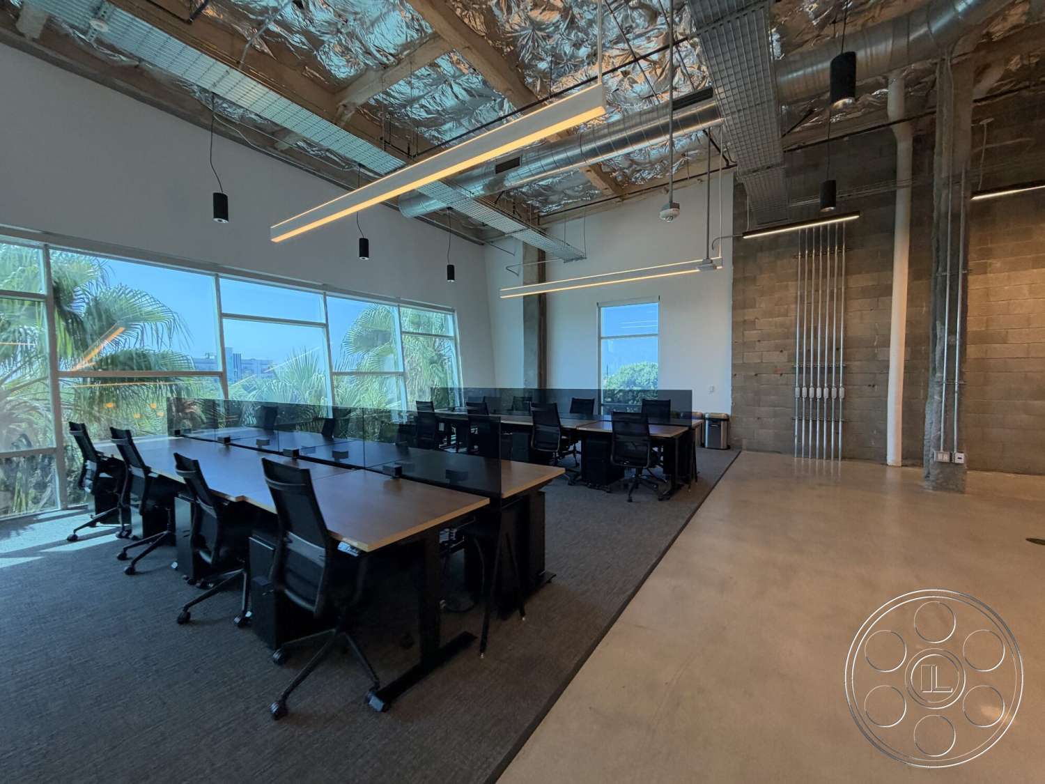 Office 130 - concrete flooring, concrete block walls, polished concrete floors, glass wall partitions, exposed wood ceiling beams, contemporary office design, long rectangular conference table, large windows with city view, linear LED ceiling lights, open workspace layout, black ergonomic office chairs, metal ductwork ceiling, industrial style office