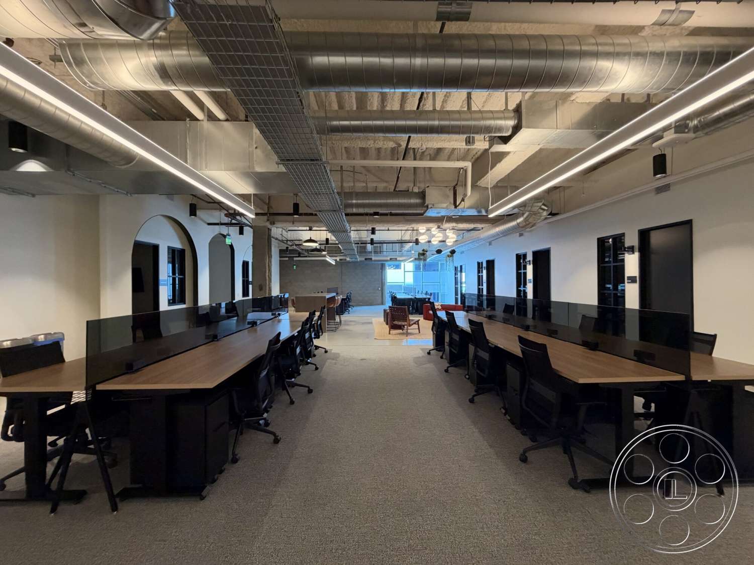 Office 130 - concrete walls, track lighting, carpet flooring, arched doorways, black office chairs, interior office space, modern office layout, exposed ductwork ceiling, wood laminate office desks, glass desk partitions