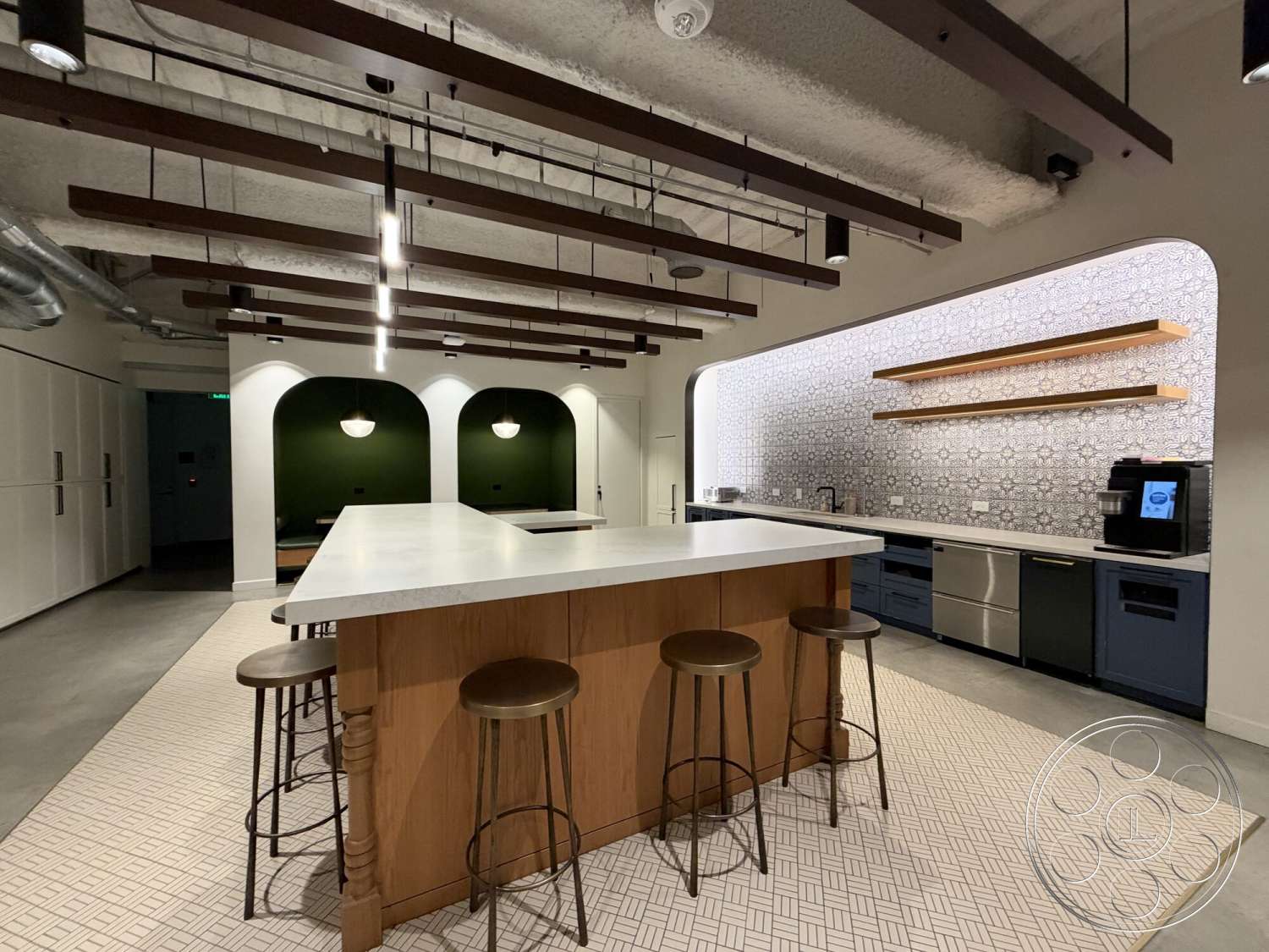 Office 130 - open shelving, concrete floor, green accent wall, wood bar stools, decorative tile backsplash, pendant lighting fixtures, exposed wood ceiling beams, marble kitchen island, smooth concrete ceiling, chefs kitchen, light fixture with black finish, monochrome patterned flooring