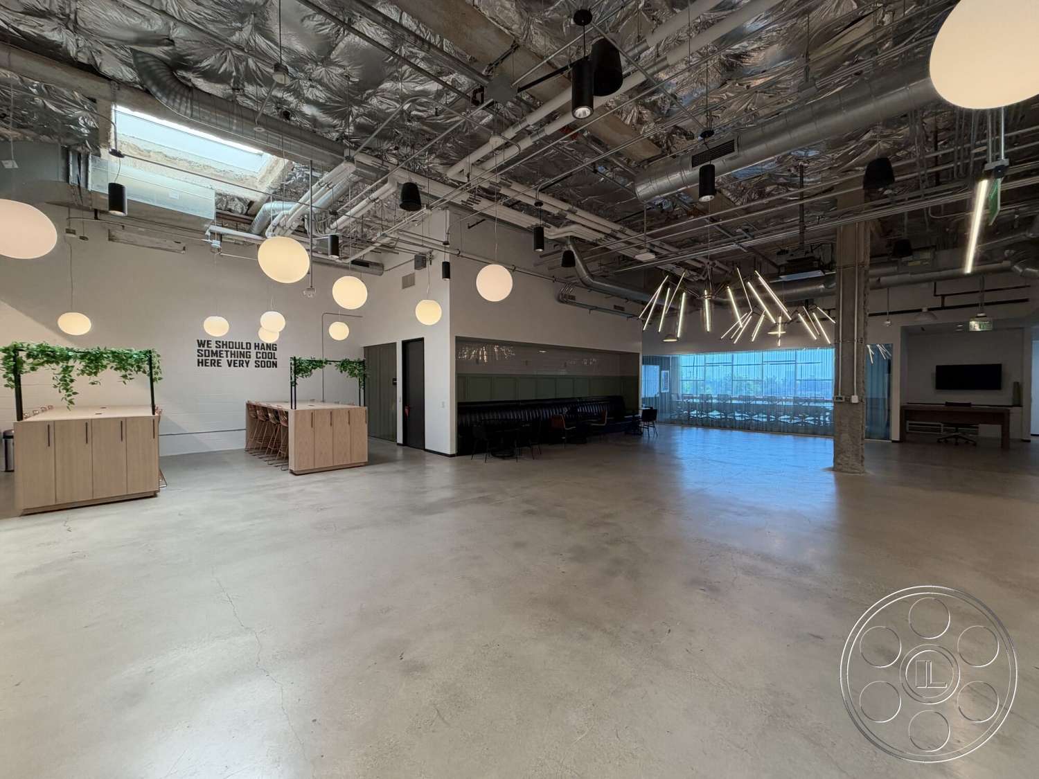 Office 130 - modern pendant lighting, floor-to-ceiling windows, contemporary interior, urban office environment, open concept workspace, glass partition wall, exposed concrete flooring, decorative greenery accents, linear LED light fixtures, suspended metal ceilings, minimalist wooden bar, industrial-style ceiling pipes