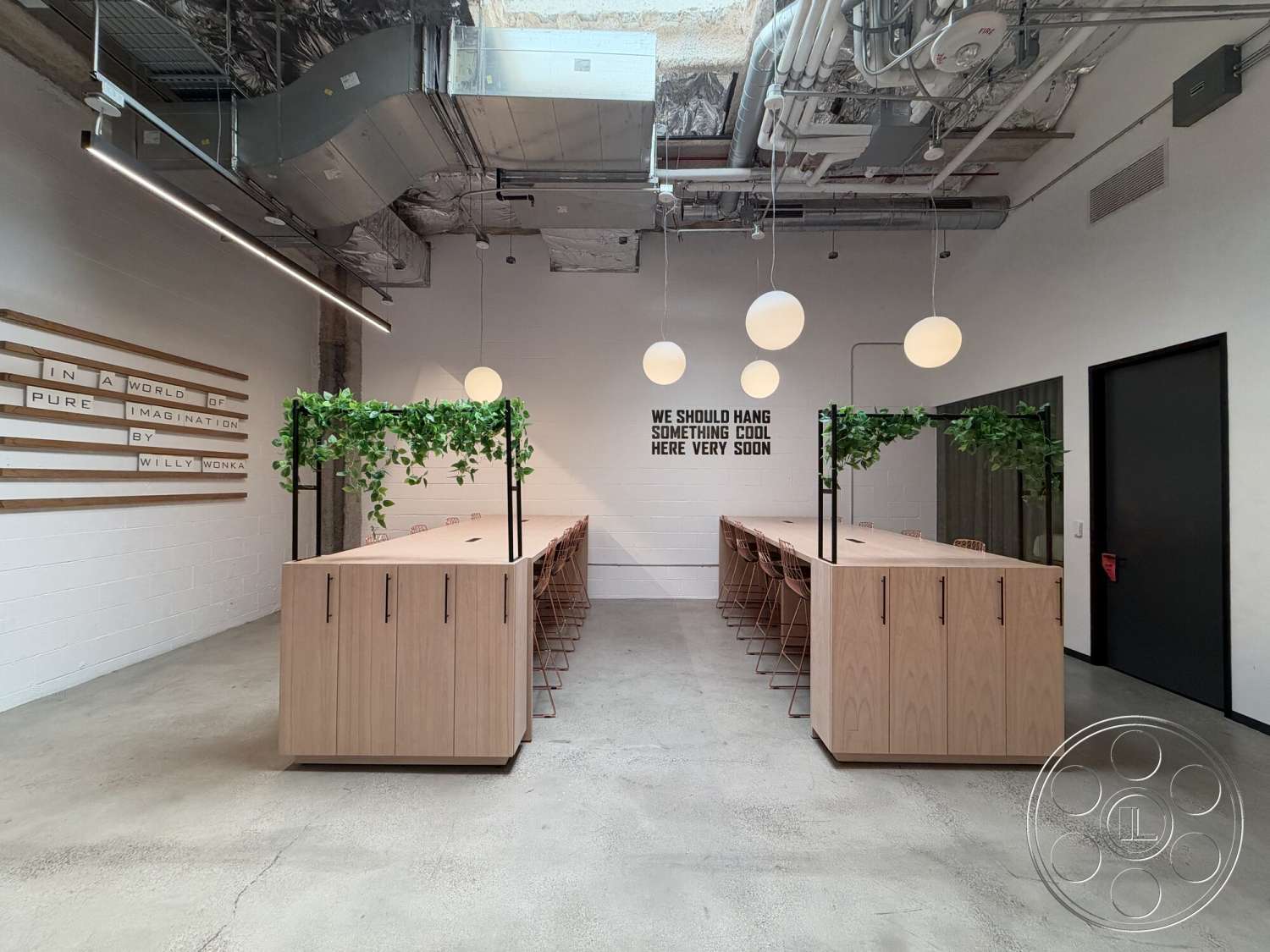 Office 130 - minimalist design elements, open concept layout, large glass windows, wooden dining table, light wood cabinetry, metal bar stools, indoor greenery, white painted walls, modern office space, exposed concrete flooring, suspended globe pendant lights, textured ceiling with industrial HVAC