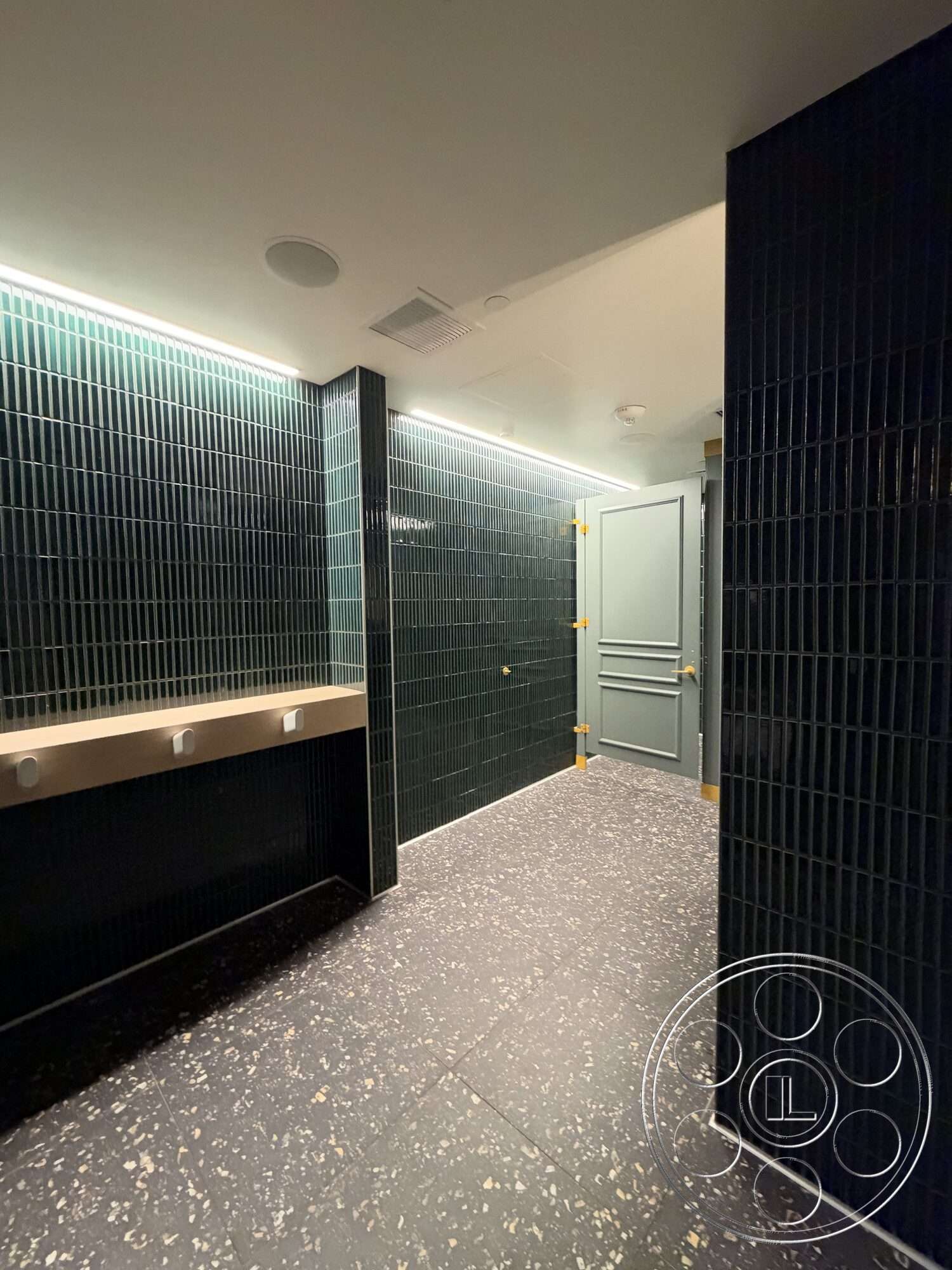Office 130 - terrazzo flooring, modern door design, textured ceramic wall tiles, soft LED ceiling lighting, dark green wall treatment, custom stone sink countertop, elegant hardware finishes