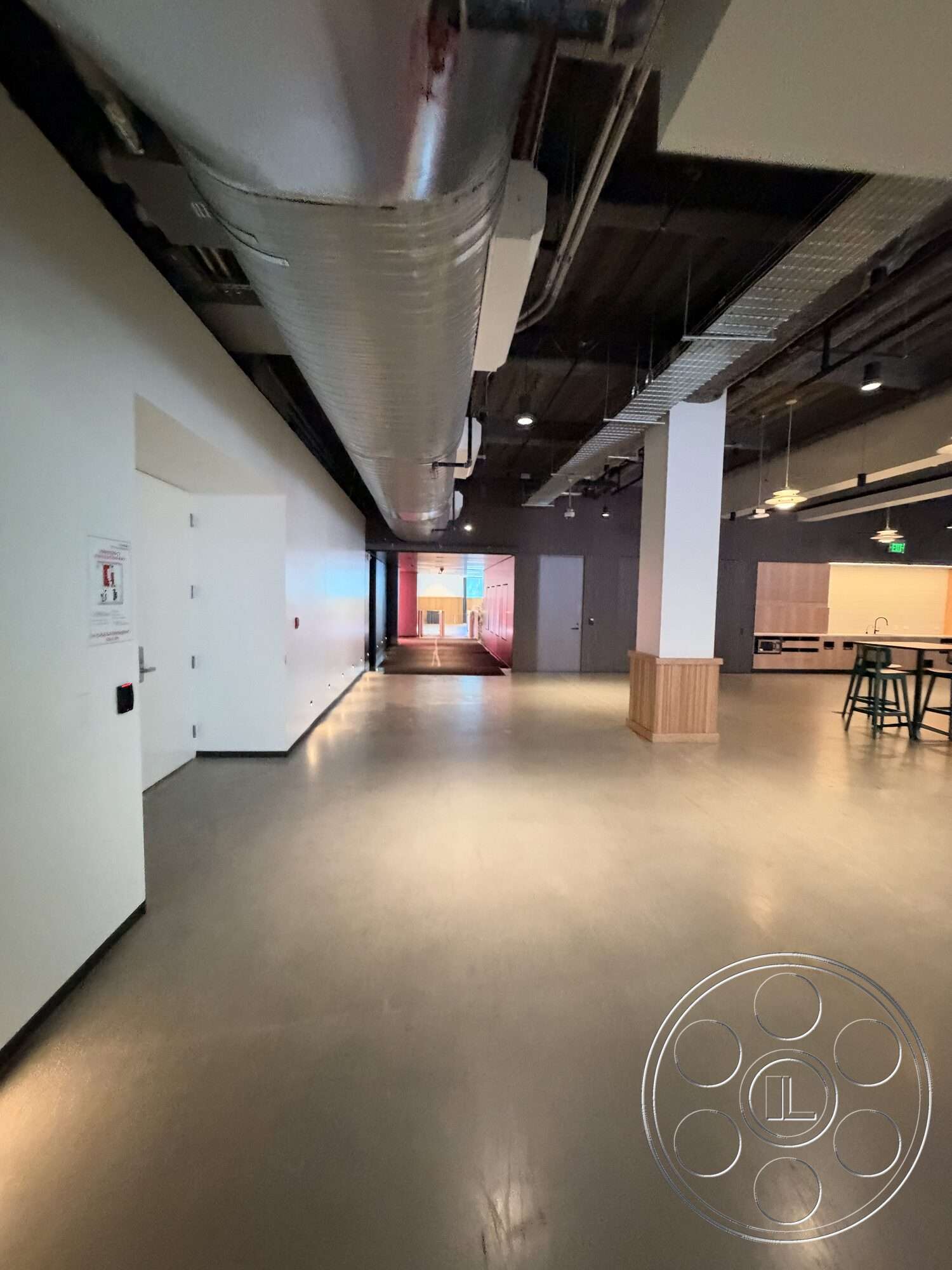 Office 130 - modern architecture, polished concrete floor, open floor plan, interior space, industrial lighting fixtures, metal staircase, white painted walls, exposed ductwork ceiling, wood bar counter, flush electrical outlets
