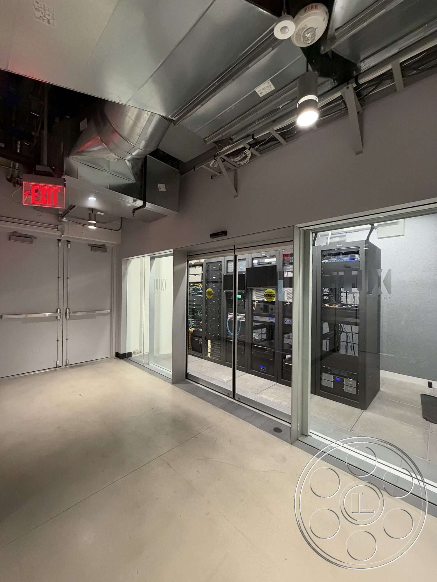 Office 130 - exterior, concrete flooring, industrial style, exposed ductwork, ceiling-mounted lighting, glass partition walls, modern interior design, steel frame construction, double glass doors, technology equipment room