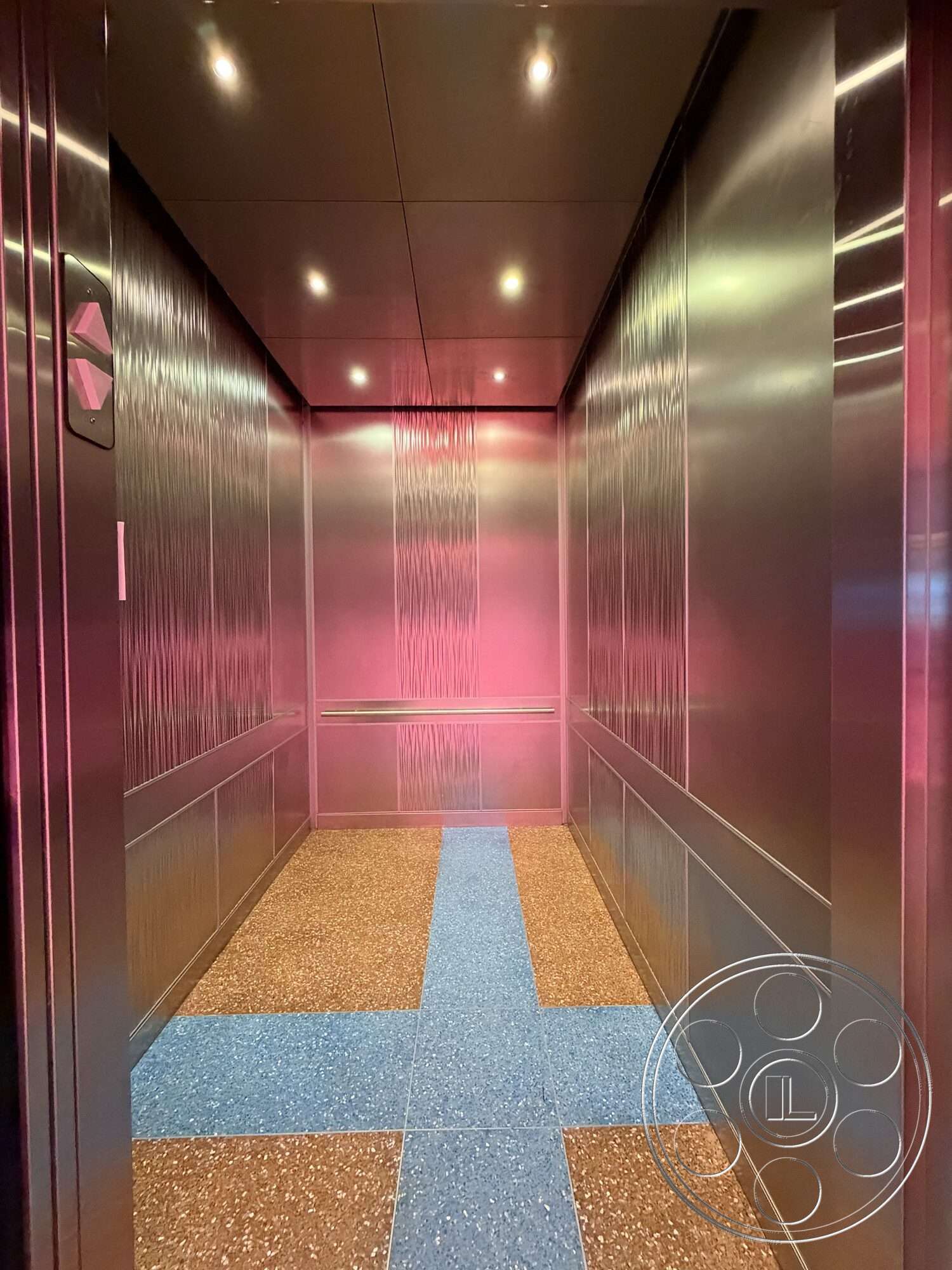 Office 130 - terrazzo flooring, modern lighting fixtures, minimalist design elements, textured wall treatment, metal wall panels, interior elevator, reflective paneling, blue terrazzo accent strip, high-gloss ceiling finish
