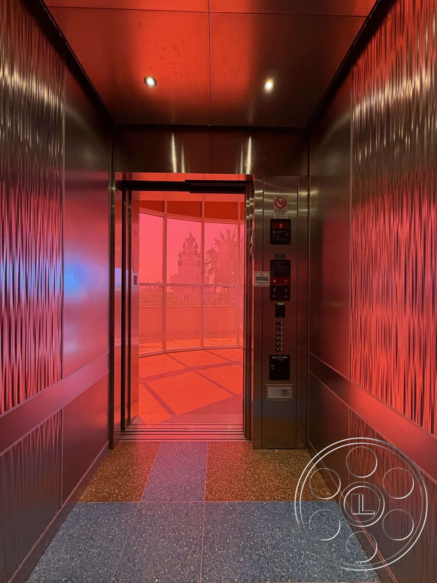 Office 130 - terrazzo floor, glass elevator doors, illuminated ceiling lights, interior elevator space, stainless steel elevator walls, decorative textured stainless steel paneling, control panel with elevator buttons