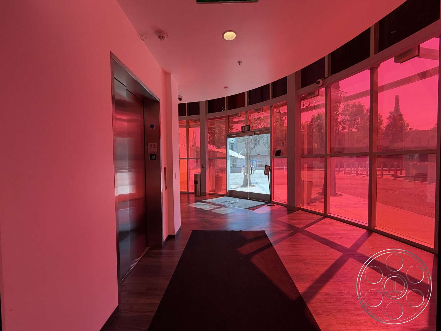 Office 130 - wood flooring, exterior, modern architectural style, elevator door, black area rug, painted drywall walls, glass entry doors, curved glass windows