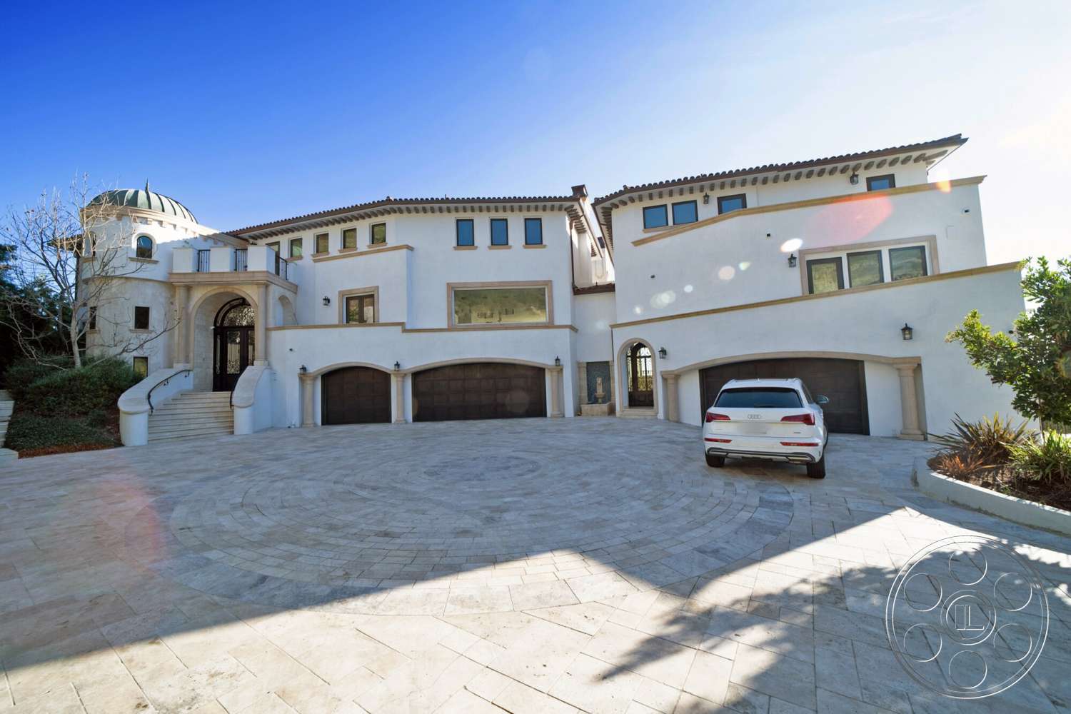 Medit 169 - exterior, floor-to-ceiling windows, circular driveway, stucco walls, arched doorways, arched windows, modern garage doors, landscaped garden area, decorative stone accents, modern residential design, paver stone driveway, barrel tile roof, multi-level facade, dome roof structure, porch stairs
