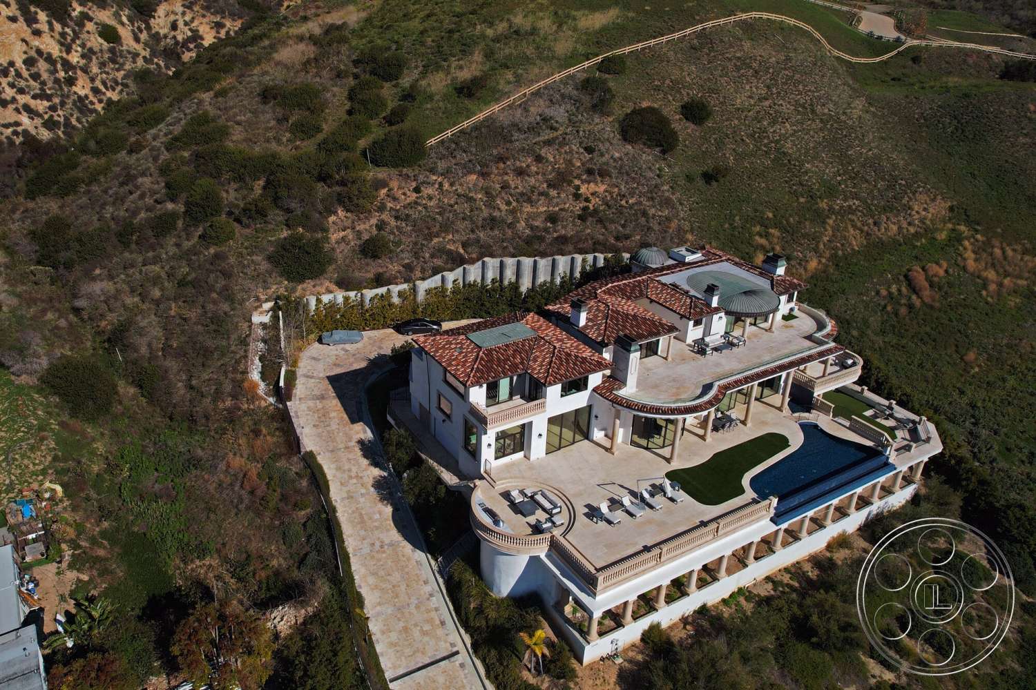 Medit 169 - exterior, large glass sliding doors, metal railing, outdoor lounge area, Mediterranean architecture, arched windows, poolside loungers, concrete pool deck, landscape greenery, hillside location, multi-level terrace, rectangle swimming pool, stucco exterior walls, open-air balcony, terra cotta tile roof, expansive stone patio, columns with decorative details