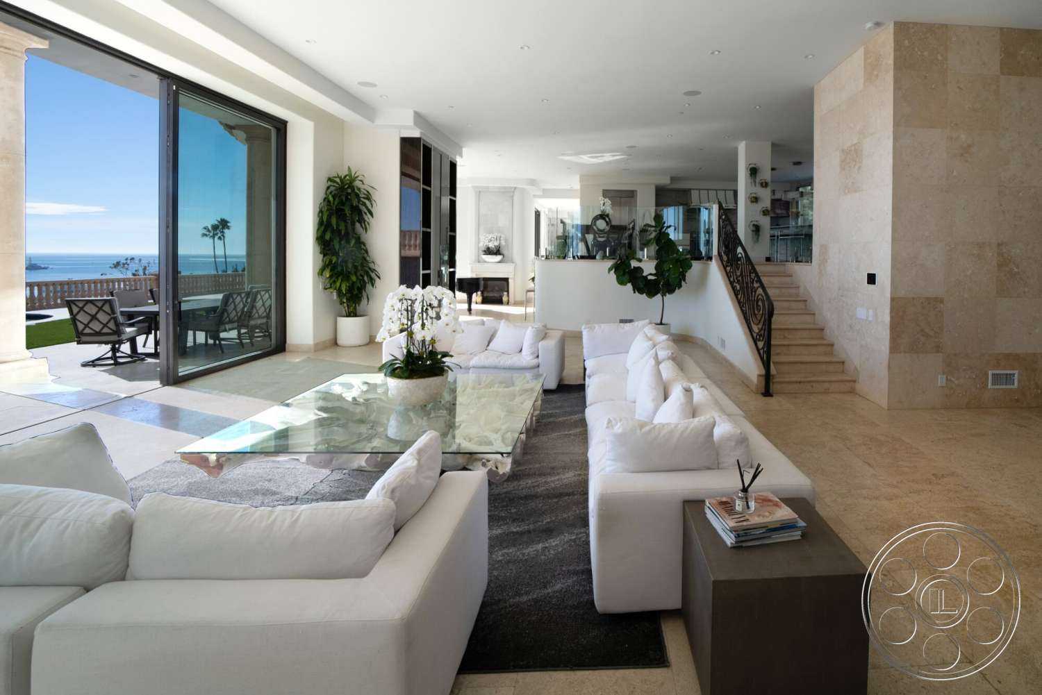 Medit 169 - high ceilings, neutral color palette, large windows, decorative area rug, glass coffee table, minimalist design elements, seamless indoor-outdoor transition, decorative wall art, natural stone flooring, potted greenery, open concept living room, white sectional sofa, stylish light fixtures, metal side table, curved staircase with wrought iron railing, coastal ocean view, wall of glass sliding doors