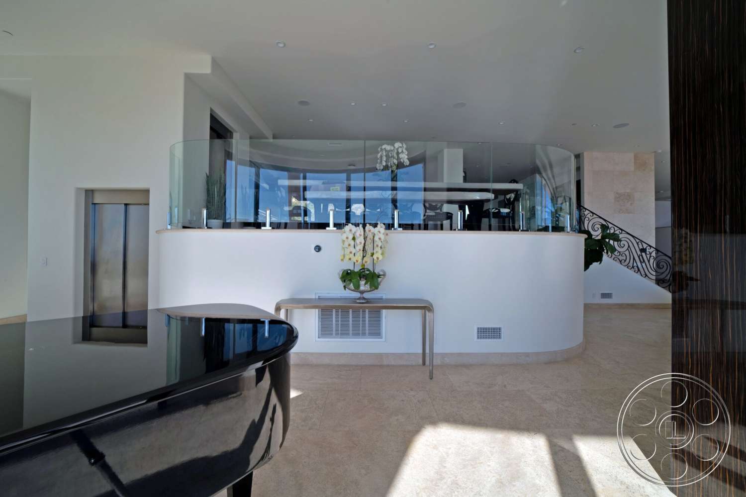 Medit 169 - contemporary style, floor-to-ceiling windows, black grand piano, polished marble flooring, metal handrail, natural light-filled space, minimalist interior design, white painted walls, open floor plan design, luxury residential setting, modern bar countertop, stainless steel elevator door, curved glass partition wall