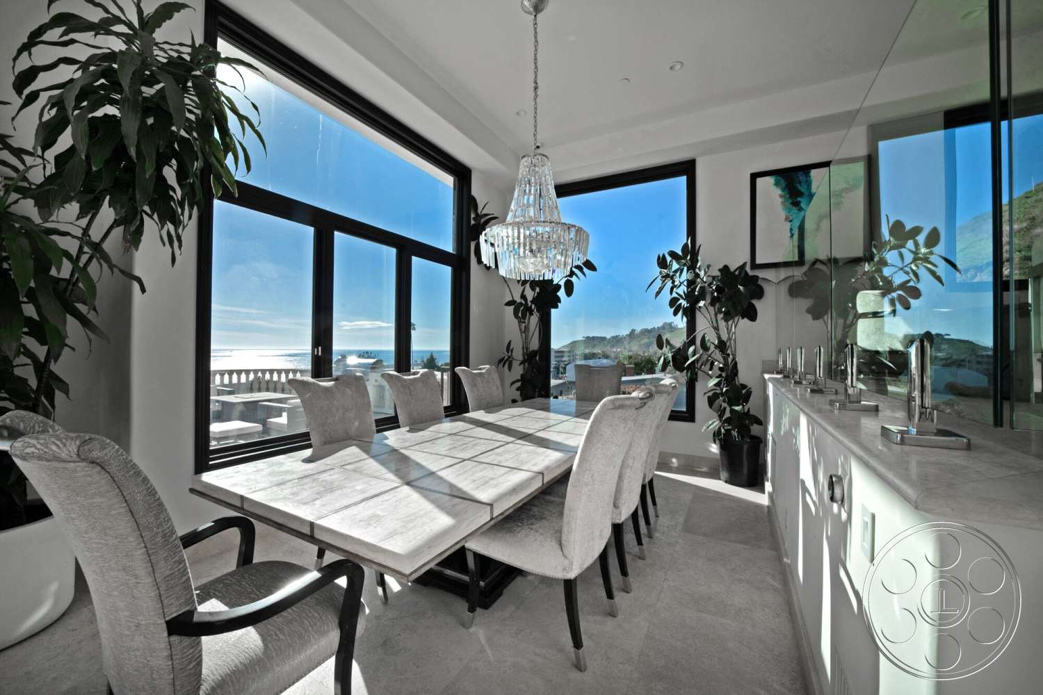 Medit 169 - open floor plan, upholstered dining chairs, floor-to-ceiling windows, textured wall treatment, rectangular dining table, coastal setting, beachfront view, large indoor plants, chandelier light fixture, light-colored tile flooring, interior dining area, minimalist kitchen design, metal frame windows, marble dining table top, stone kitchen countertop