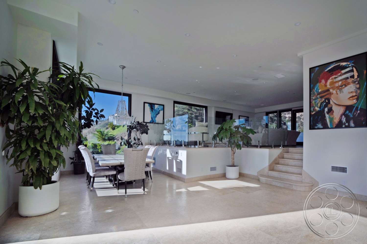 Medit 169 - minimalist decor, indoor plants, open floor plan, upholstered dining chairs, artwork on walls, floor-to-ceiling windows, natural stone flooring, bright and airy atmosphere, contemporary dining area, modern dining table, neutral painted walls, glass partition wall, high pendant lighting, staircase with natural stone steps