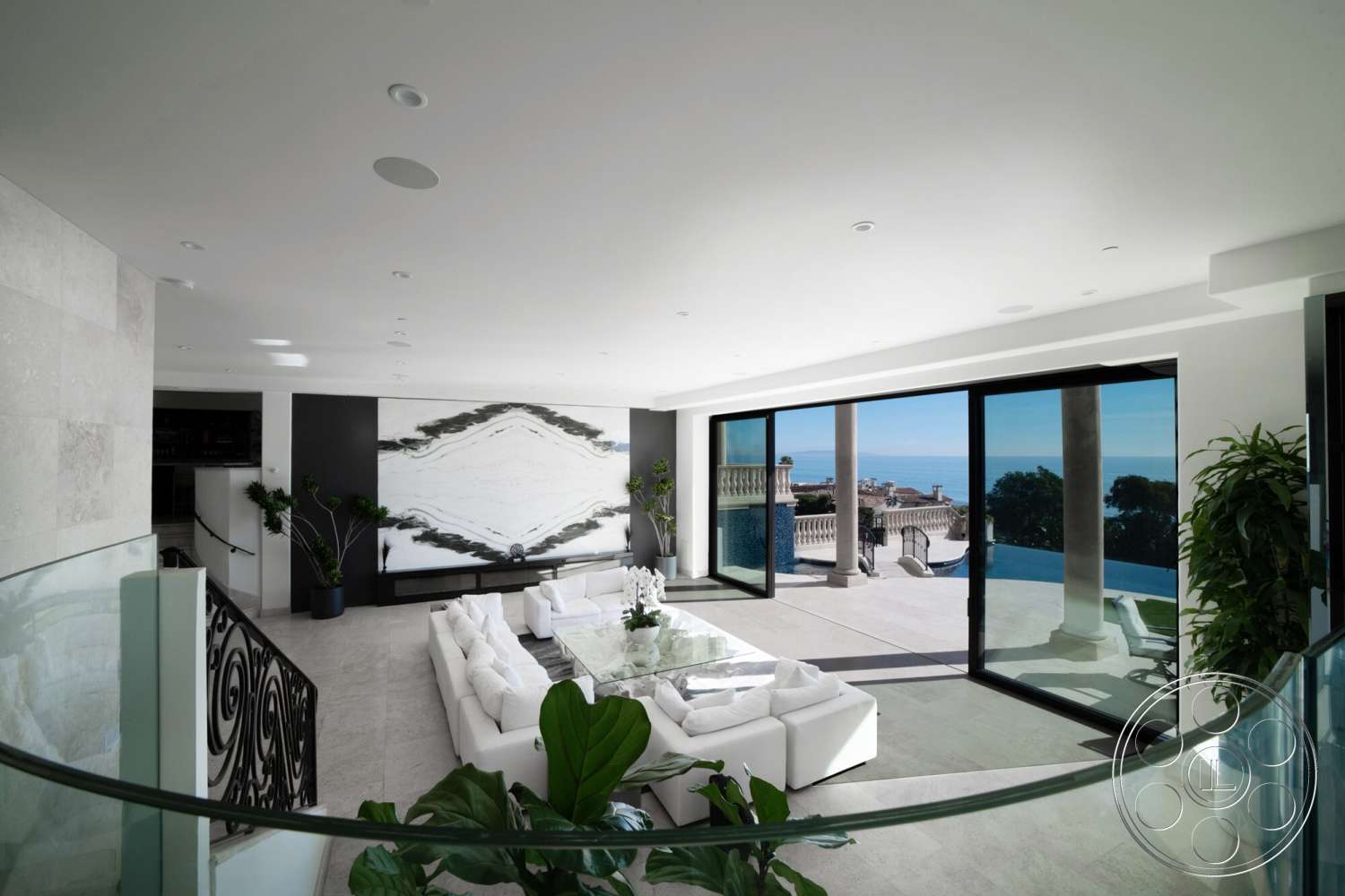 Medit 169 - neutral color palette, glass coffee table, minimalist style, floor-to-ceiling windows, decorative wall art, marble flooring, coastal view, black railings, modern sectional sofa, indoor potted plants, exposed stone accent wall, modern ceiling lights, bright airy space, open living area