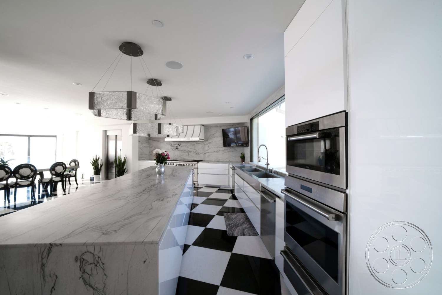 Medit 169 - minimalist design, stainless steel appliances, sconce lighting, floor-to-ceiling windows, white cabinetry, decorative potted plants, stylish dining area, luxury kitchen space, marble kitchen island countertop, open-concept kitchen, modern chandelier lighting, black and white checkered tile flooring, linear kitchen layout, sleek kitchen backsplash