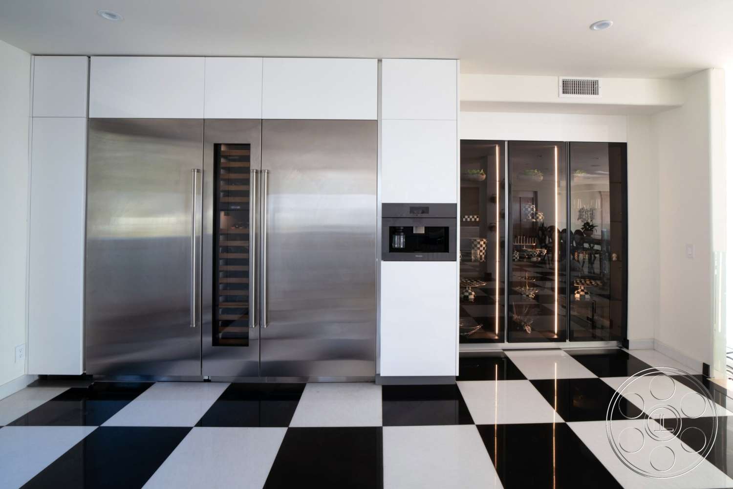Medit 169 - white cabinetry, stainless steel refrigerator, modern kitchen design, open kitchen layout, minimalist kitchen style, black and white checkered tile flooring, black glass cabinet doors, stainless steel wall oven