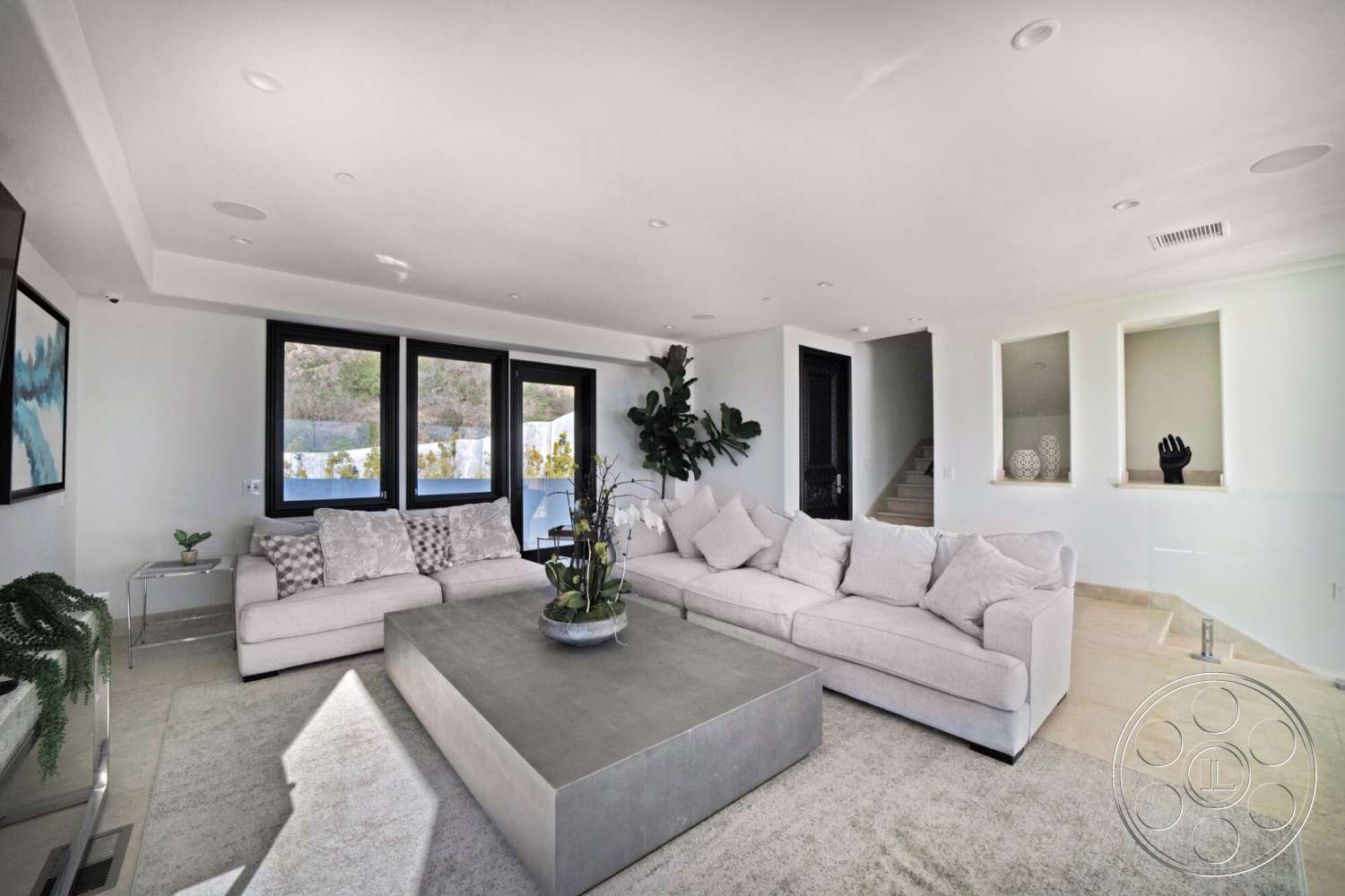 Medit 169 - textured wall panels, green indoor plants, large floor-to-ceiling windows, recessed ceiling lights, concrete coffee table, neutral painted walls, stone staircase, soft beige area rug, light-colored plush sofa