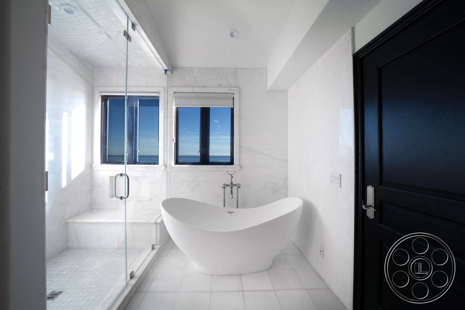 Medit 169 - black wooden door, minimalist bathroom design, frameless glass shower enclosure, polished marble bathroom flooring, white marble shower walls, freestanding oval soaking tub, modern chrome bath fixtures, floor-to-ceiling windows with ocean views, natural light with oceanfront setting
