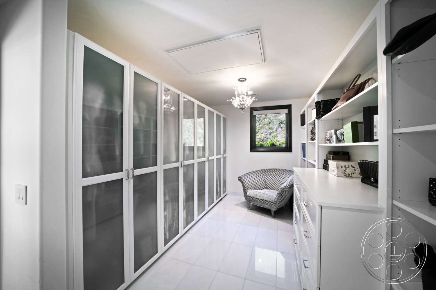 Medit 169 - contemporary design elements, black framed window, recessed ceiling lights, chandelier light fixture, woven armchair, open shelving units, modern white cabinetry, white porcelain tile flooring, glass-front wardrobe doors, minimalist storage solutions