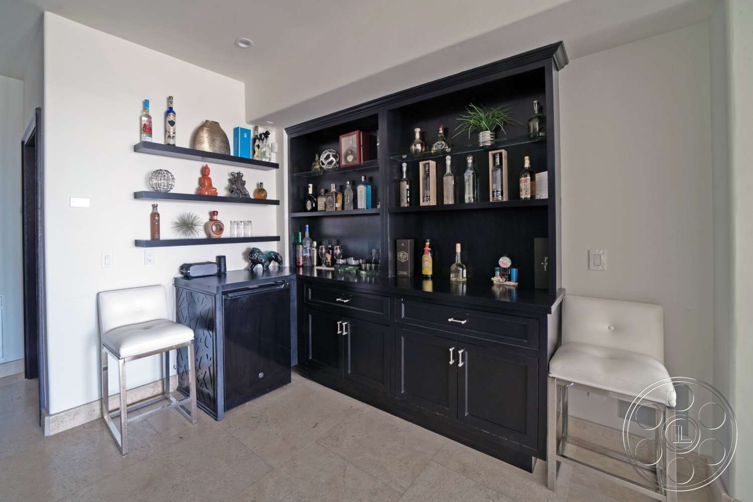 Medit 169 - modern design elements, glass door access, marble floor tiles, light-colored painted walls, black cabinetry bar unit, white leather bar stools, open wall shelves, decorative items display