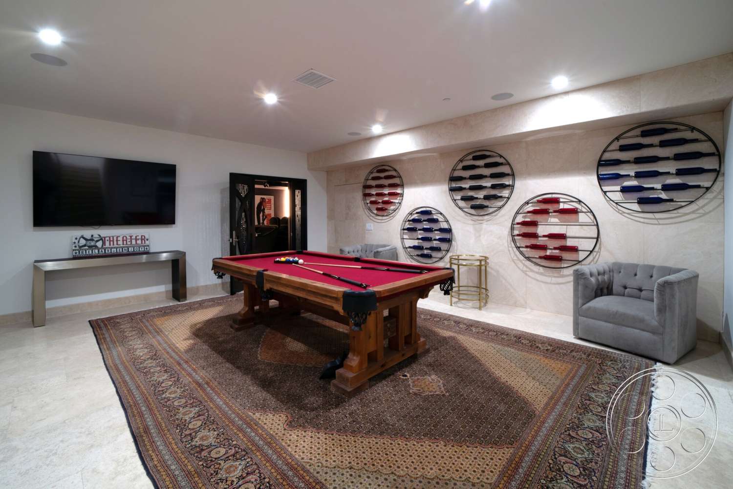 Medit 169 - tile flooring, textured area rug, stone feature wall, recessed ceiling lighting, neutral painted walls, wall-mounted flat-screen TV, decorative signage, metal wall art, wooden pool table, grey tufted armchair, modern bar cart, cloakroom door