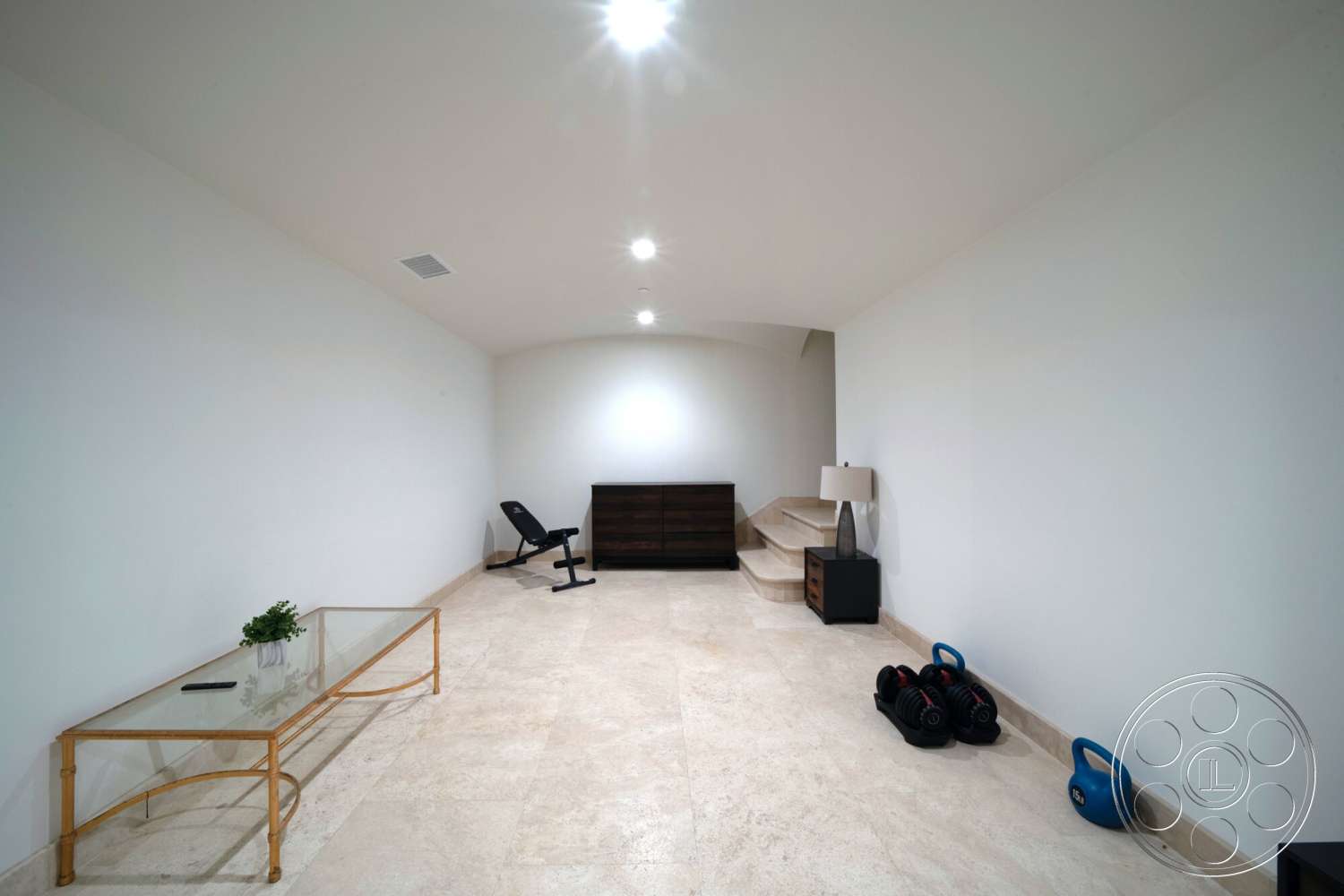 Medit 169 - minimalist decor, recessed lighting, contemporary design, glass coffee table, beige stone flooring, dark wood dresser, floating staircase, white painted walls, home gym area