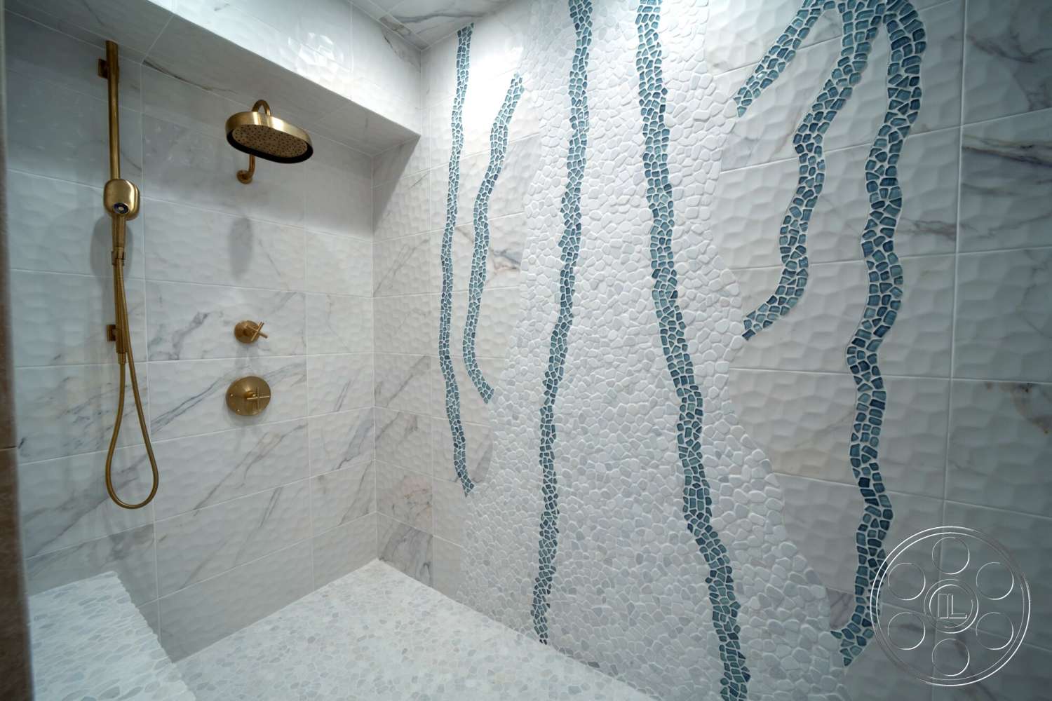 Medit 169 - interior shower space, built-in shower bench, pebble stone shower floor, marble tile walls, textured white tile wall treatment, blue mosaic stone accents, golden rain showerhead, gold shower controls, modern fixture design