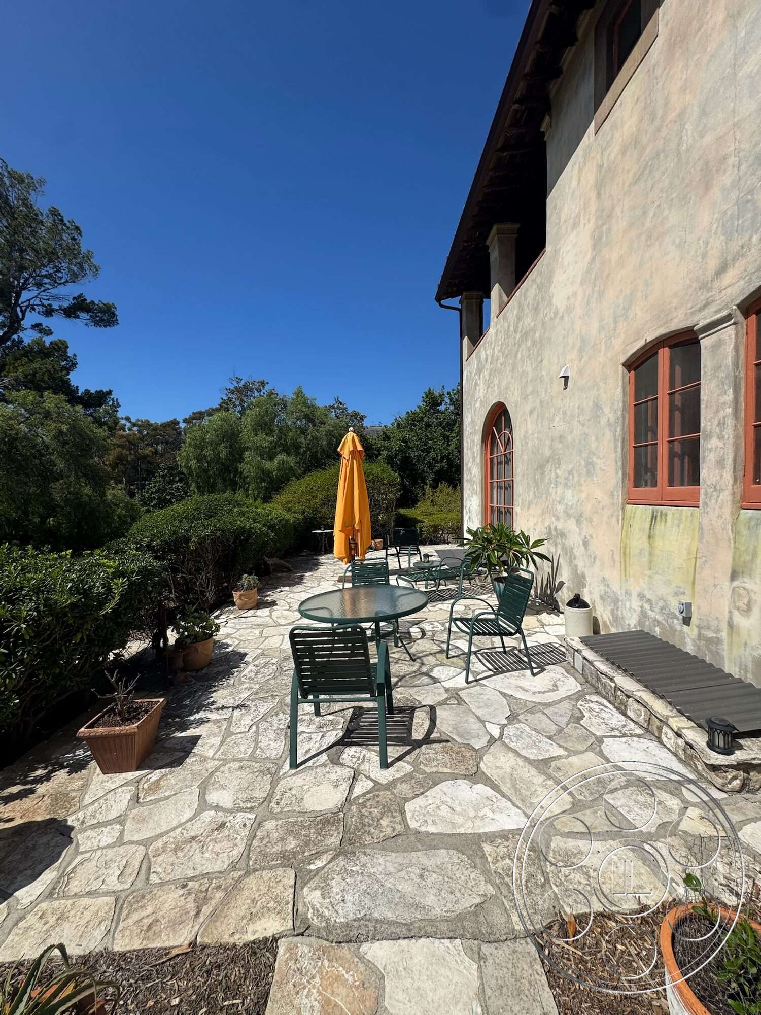 Farmstead Garden - exterior, landscaped gardens, natural stone path, red window frames, metal outdoor chairs, stucco wall finish, stone patio flooring, round outdoor dining table, yellow outdoor umbrella, modern outdoor planters